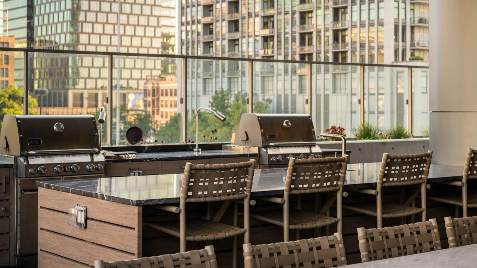 Modern outdoor grilling station at Onni Fulton Market in Chicago, featuring multiple grills, bar seating, and urban surroundings