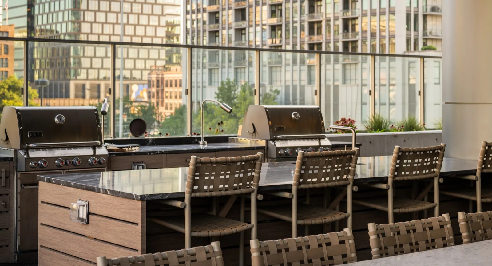 Modern outdoor grilling station at Onni Fulton Market in Chicago, featuring multiple grills, bar seating, and urban surroundings