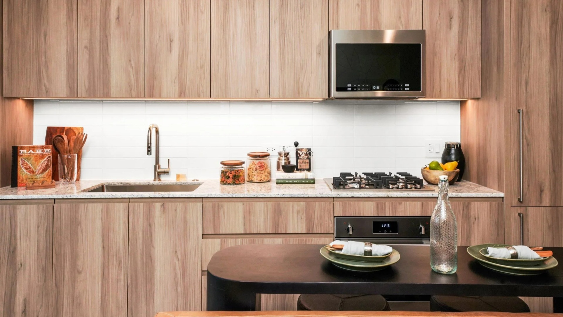 Elegant kitchen at Onni Fulton Market in Chicago, featuring warm wood cabinetry, modern appliances, and granite countertops