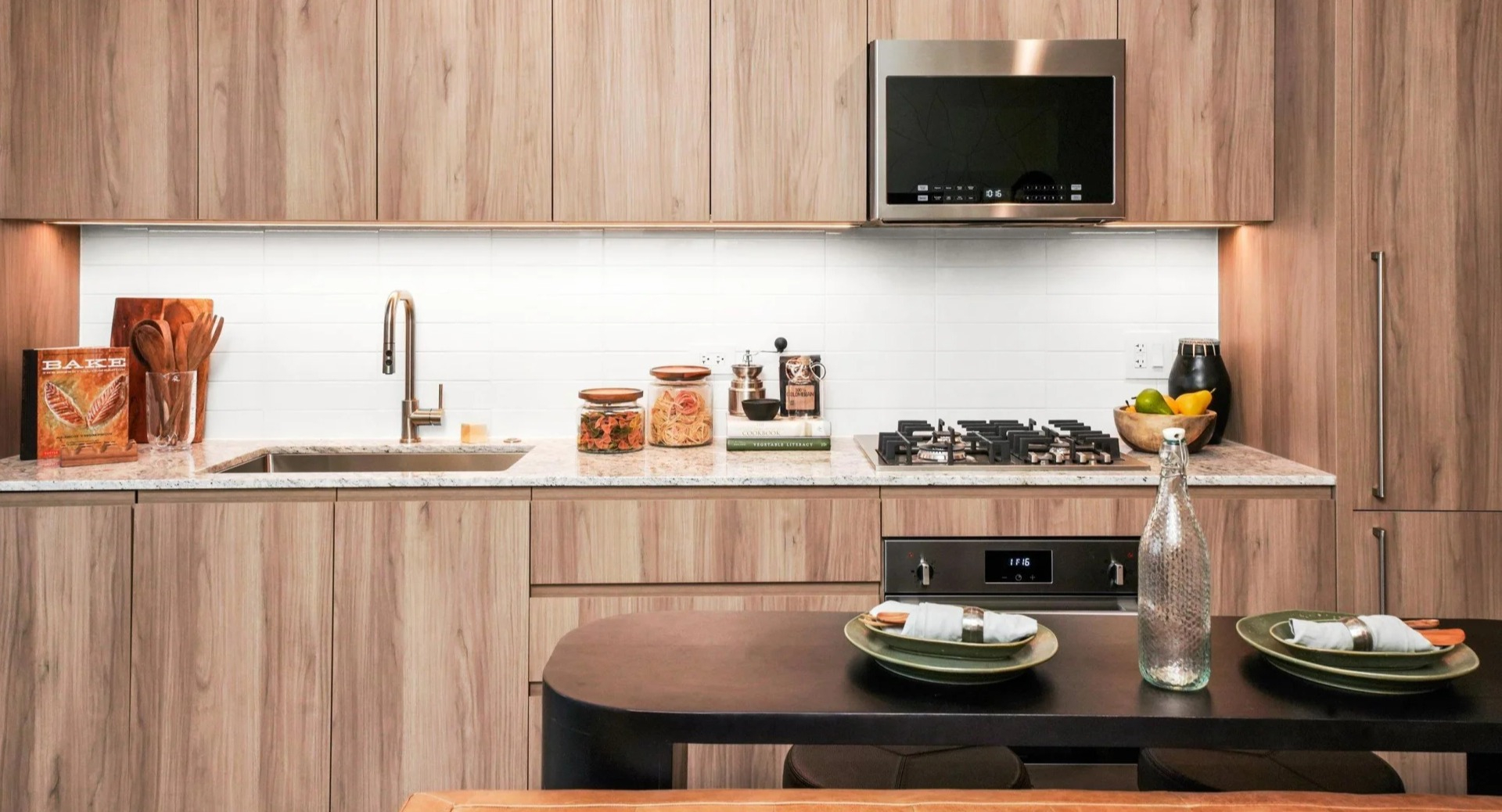 Elegant kitchen at Onni Fulton Market in Chicago, featuring warm wood cabinetry, modern appliances, and granite countertops