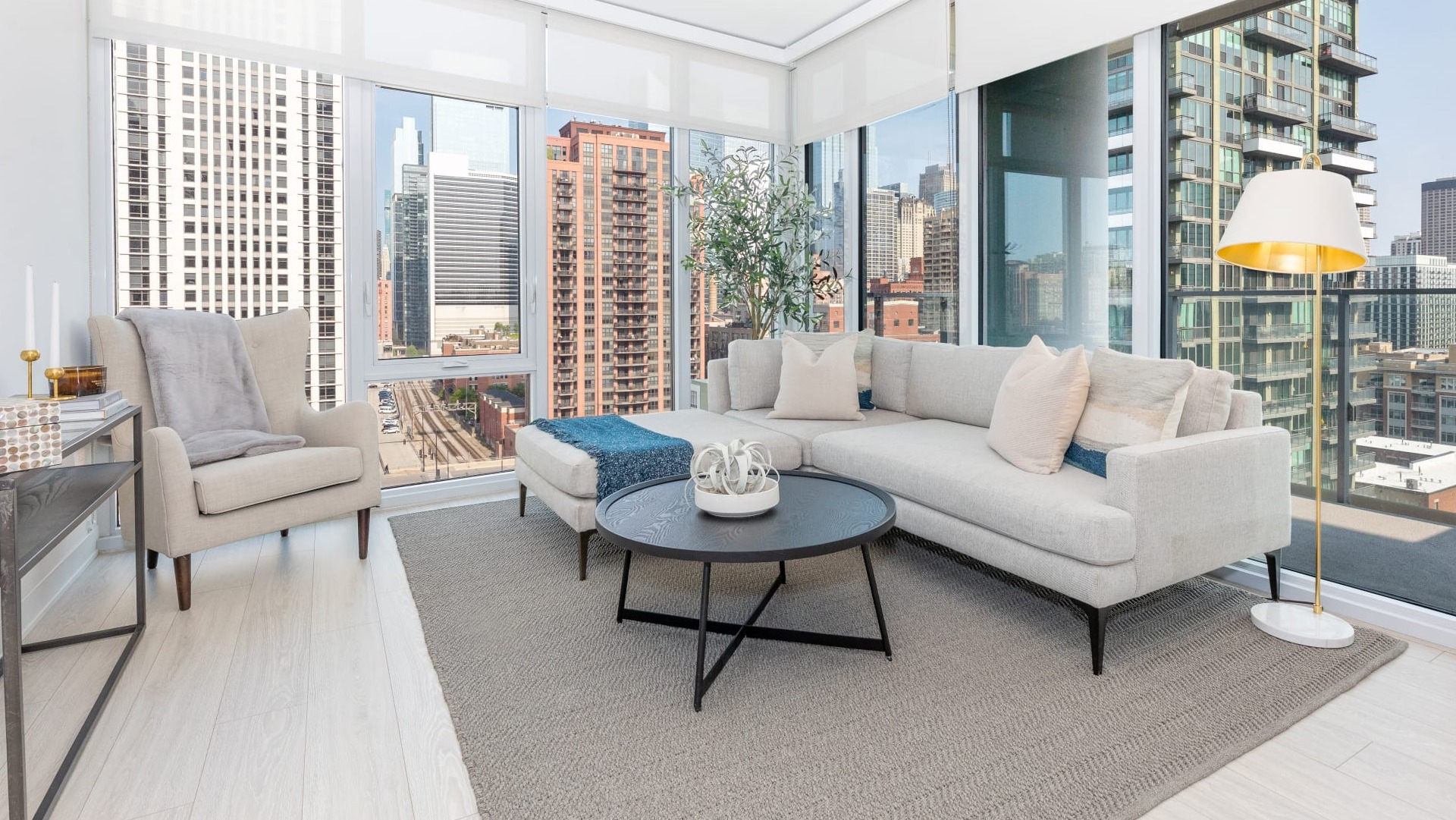 Contemporary living room at Onni Fulton Market in Chicago, featuring a large sectional sofa, modern decor, and expansive city views