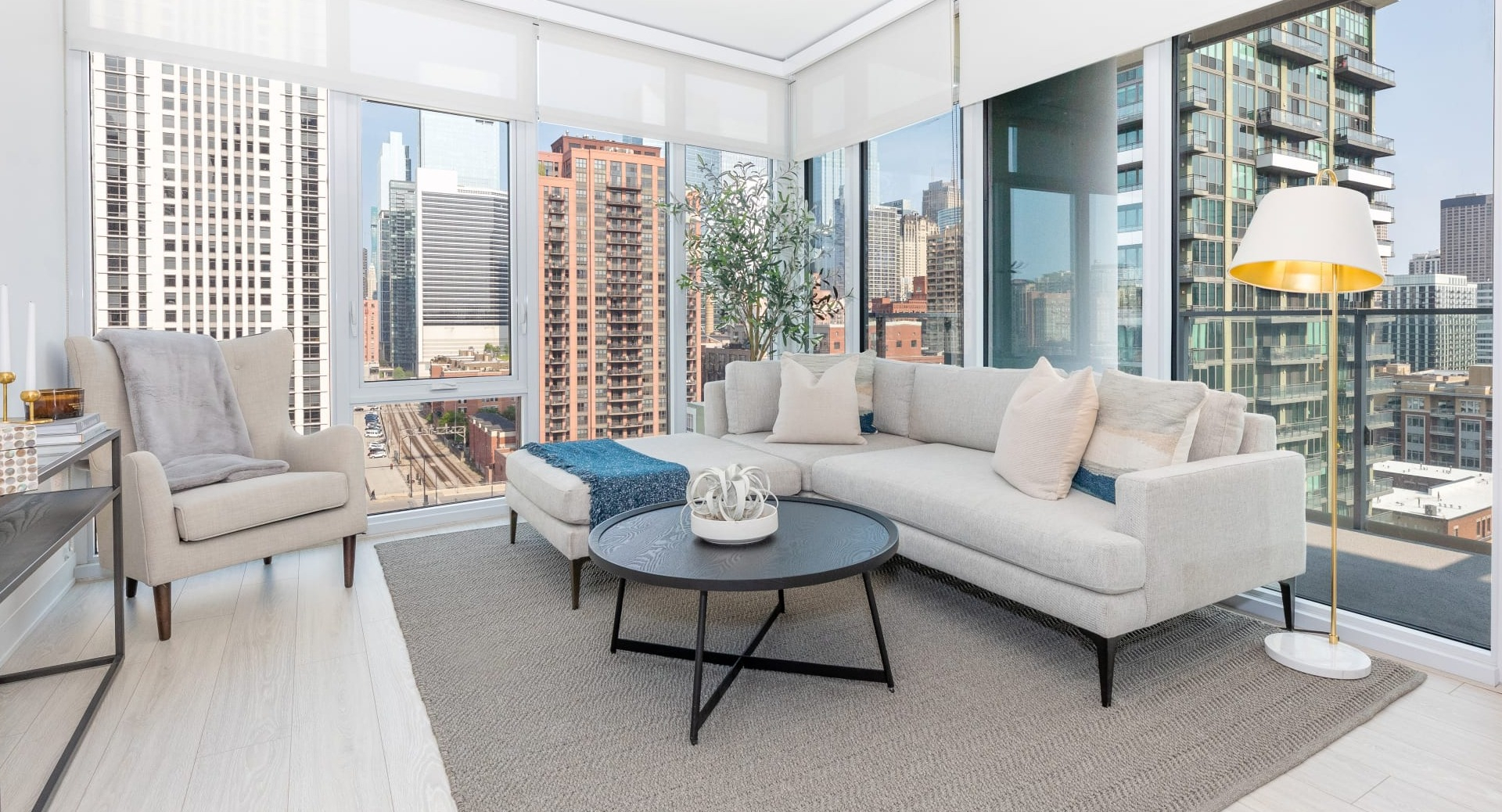 Contemporary living room at Onni Fulton Market in Chicago, featuring a large sectional sofa, modern decor, and expansive city views