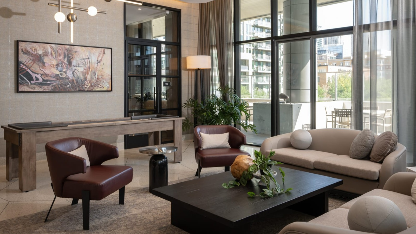 Sophisticated lounge and game room at Onni Fulton Market in Chicago, offering comfortable seating, stylish decor, and a shuffleboard table