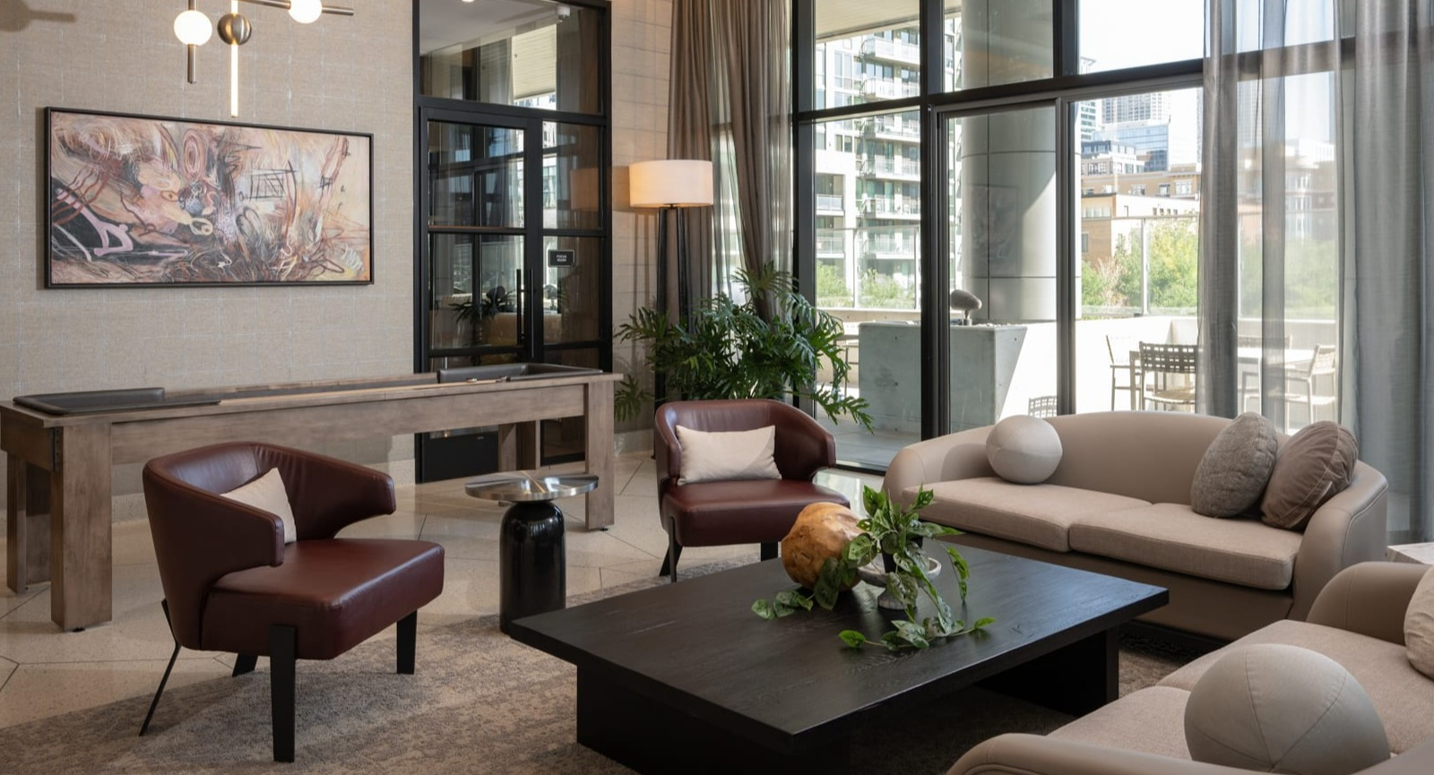 Sophisticated lounge and game room at Onni Fulton Market in Chicago, offering comfortable seating, stylish decor, and a shuffleboard table