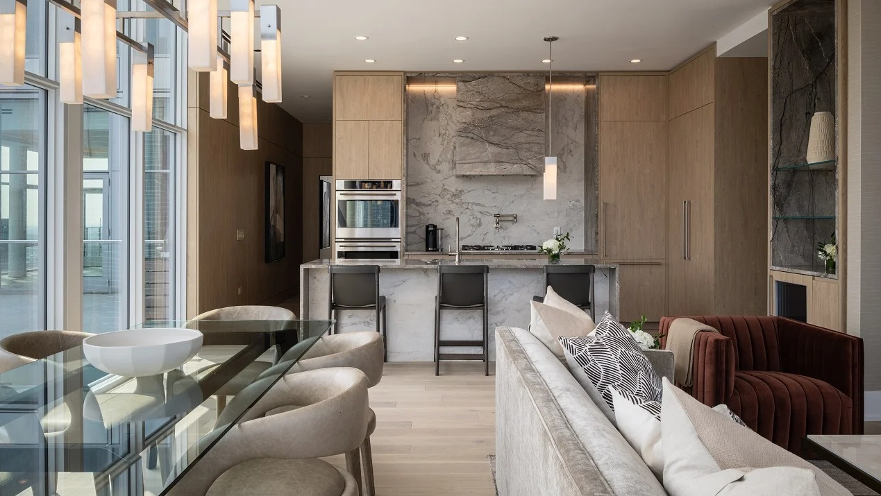 Expansive penthouse kitchen and living area at Onni Fulton Market in Chicago, featuring a modern kitchen island, dining table, and city views