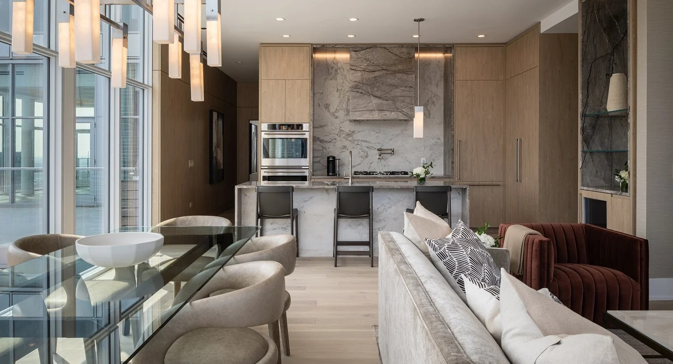 Expansive penthouse kitchen and living area at Onni Fulton Market in Chicago, featuring a modern kitchen island, dining table, and city views