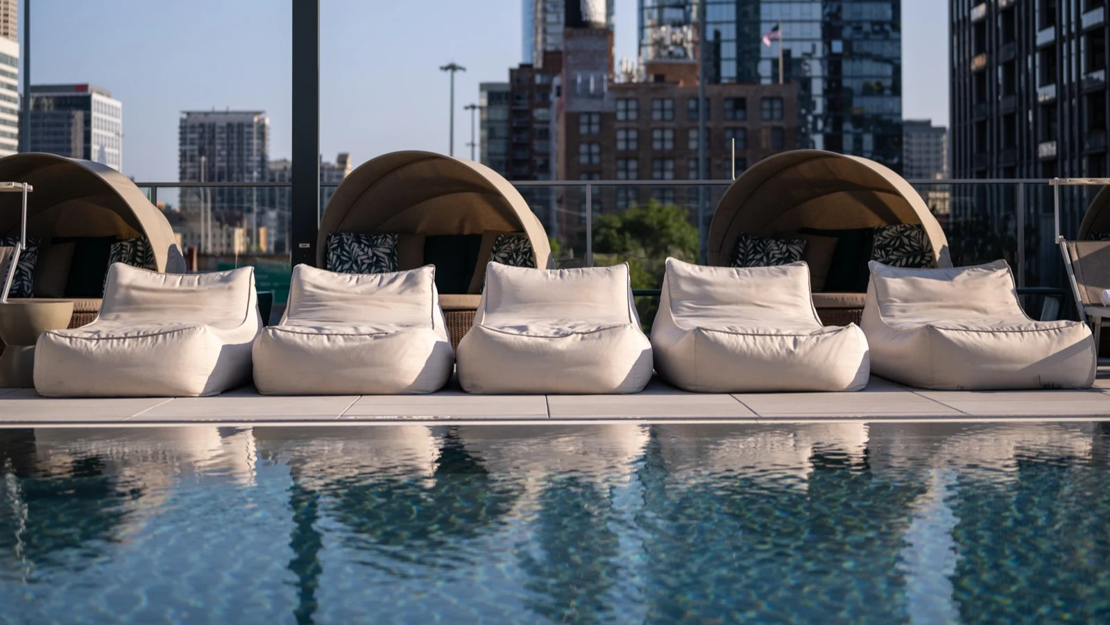 Inviting poolside area at Onni Fulton Market in Chicago, featuring comfortable lounge chairs, private cabanas, and city views