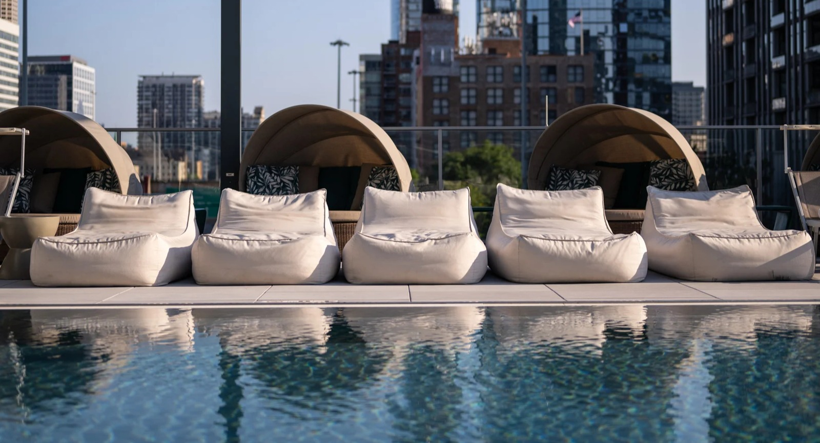 Inviting poolside area at Onni Fulton Market in Chicago, featuring comfortable lounge chairs, private cabanas, and city views