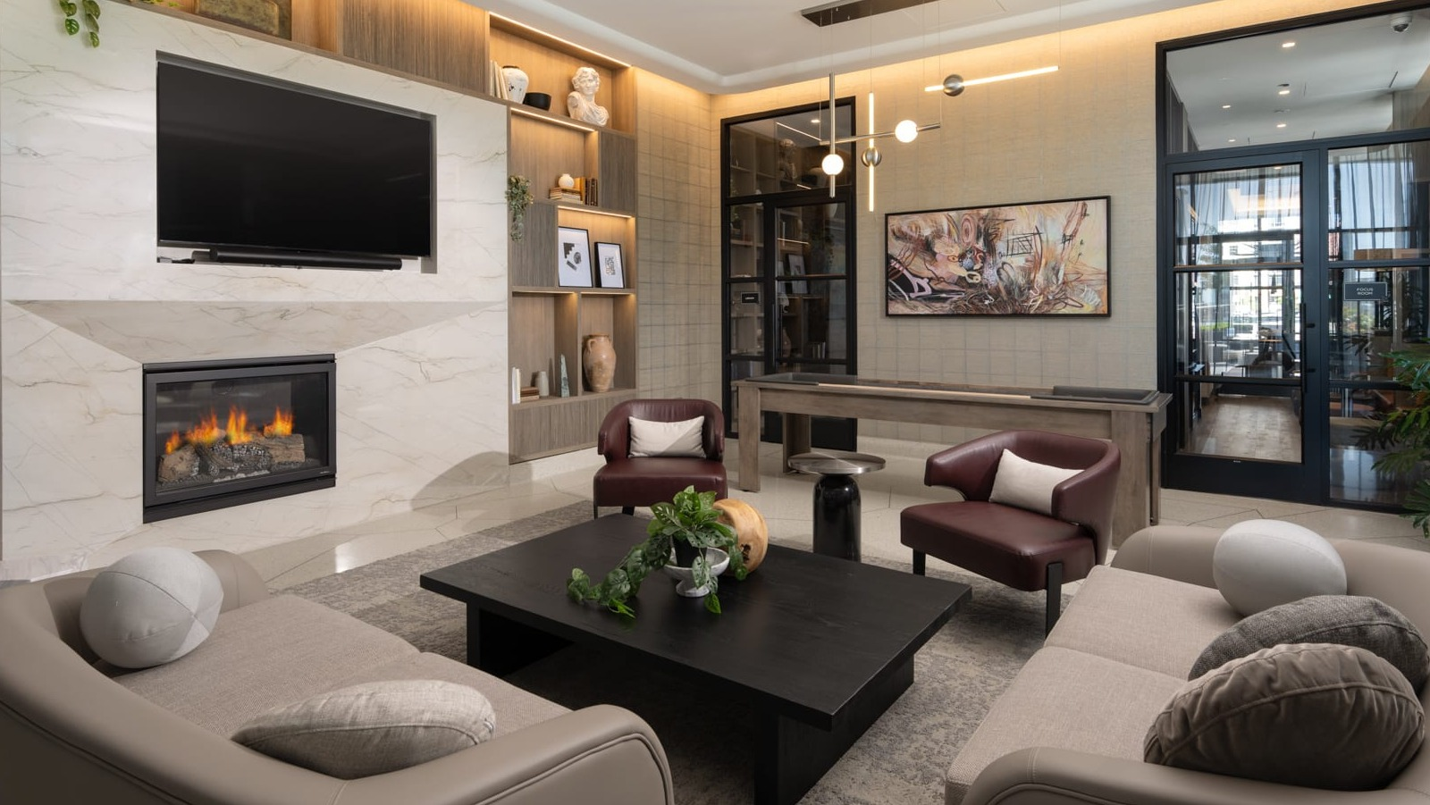 Luxurious resident lounge at Onni Fulton Market in Chicago, featuring a modern fireplace, TV, comfortable seating, and a game table