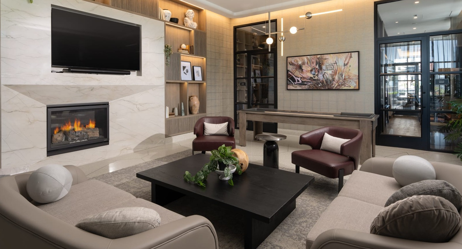 Luxurious resident lounge at Onni Fulton Market in Chicago, featuring a modern fireplace, TV, comfortable seating, and a game table