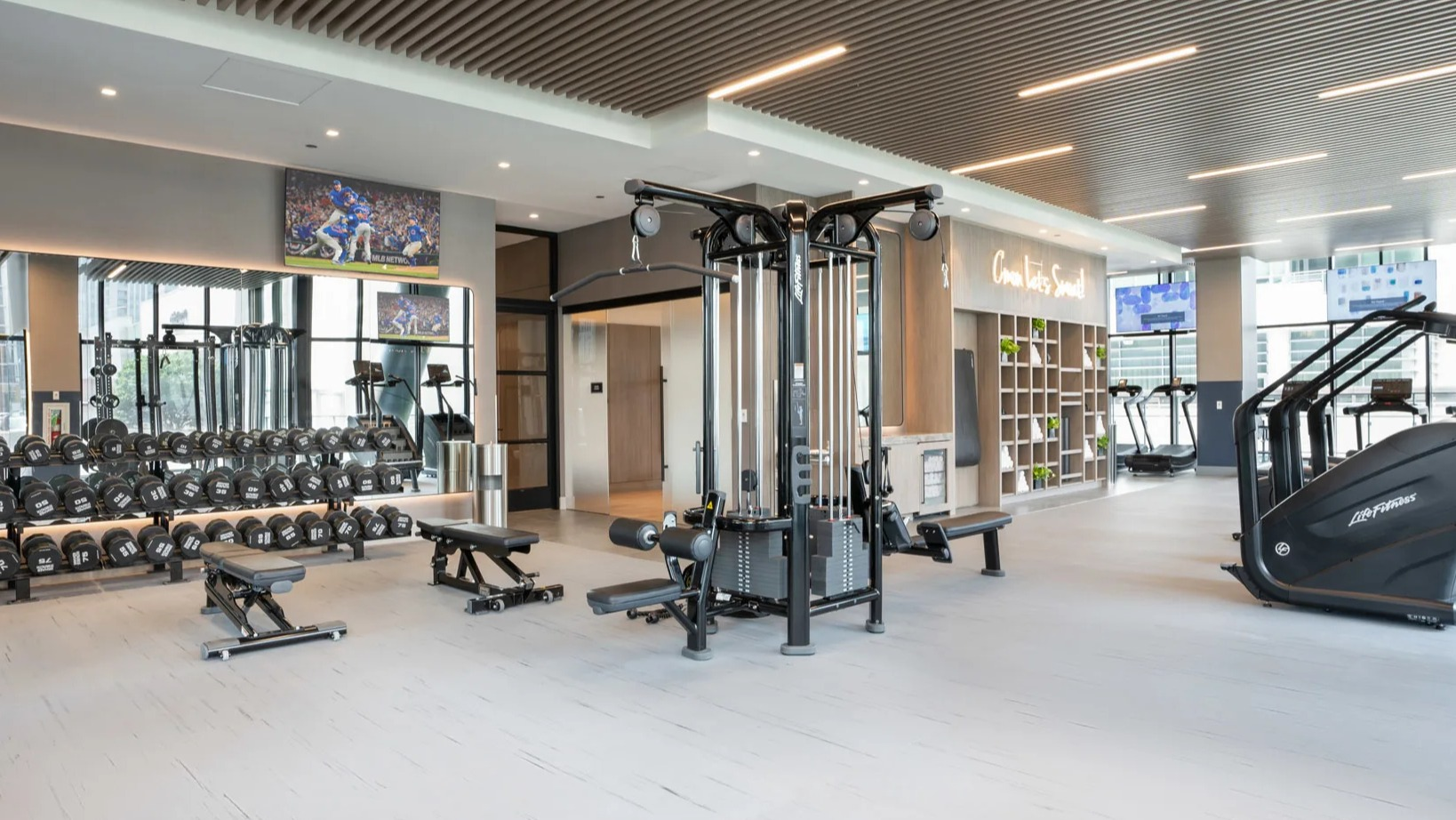 Comprehensive weights and fitness area at Onni Fulton Market in Chicago, offering free weights, strength machines, and ample space