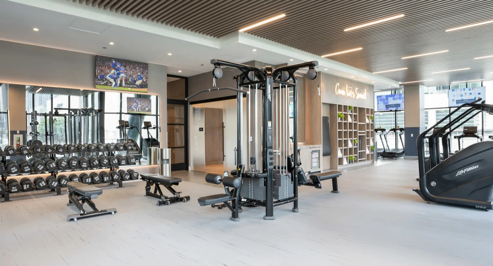 Comprehensive weights and fitness area at Onni Fulton Market in Chicago, offering free weights, strength machines, and ample space