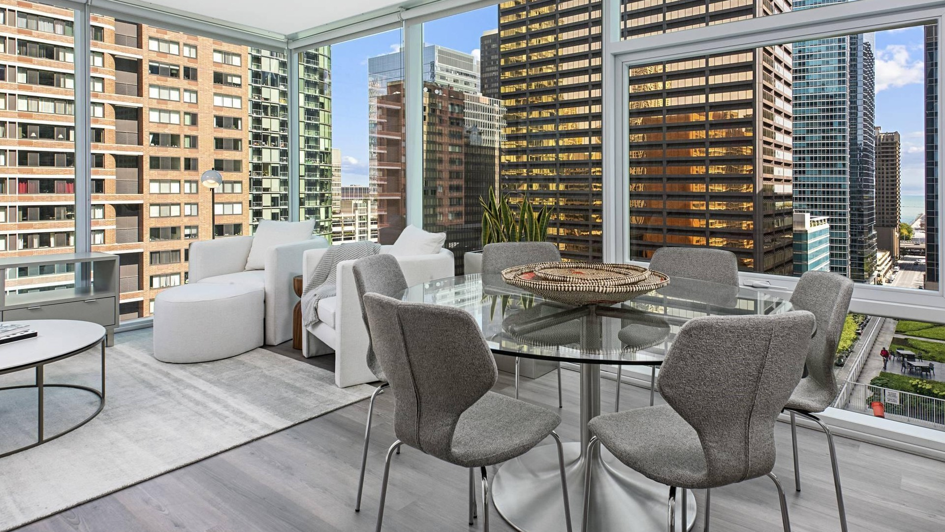 Corner dining and living area at Optima Signature with glass walls, round table, and skyline views ideal for entertaining in Chicago