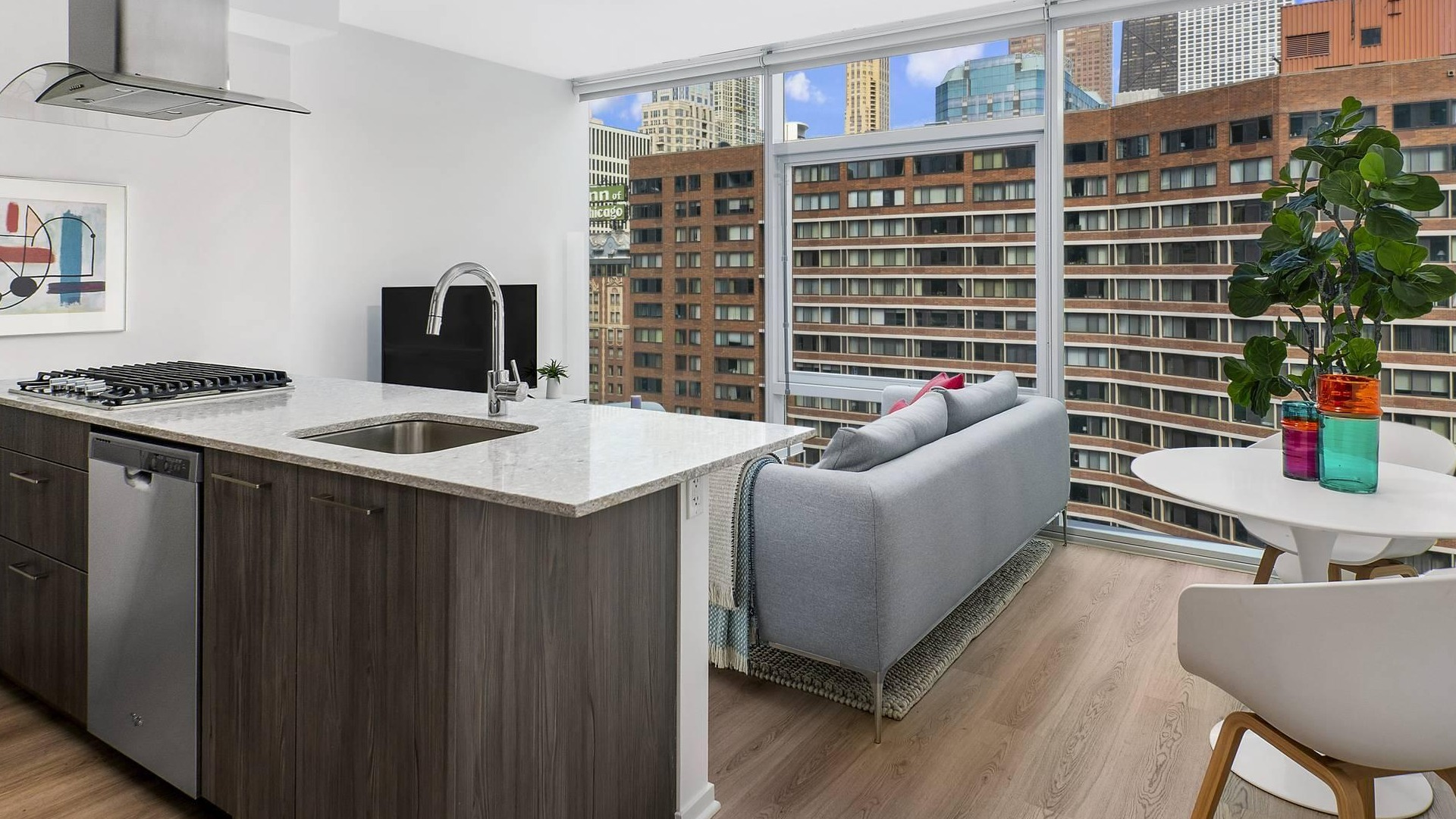 Open kitchen and living space at Optima Signature with modern finishes, breakfast bar seating, and cozy sitting area