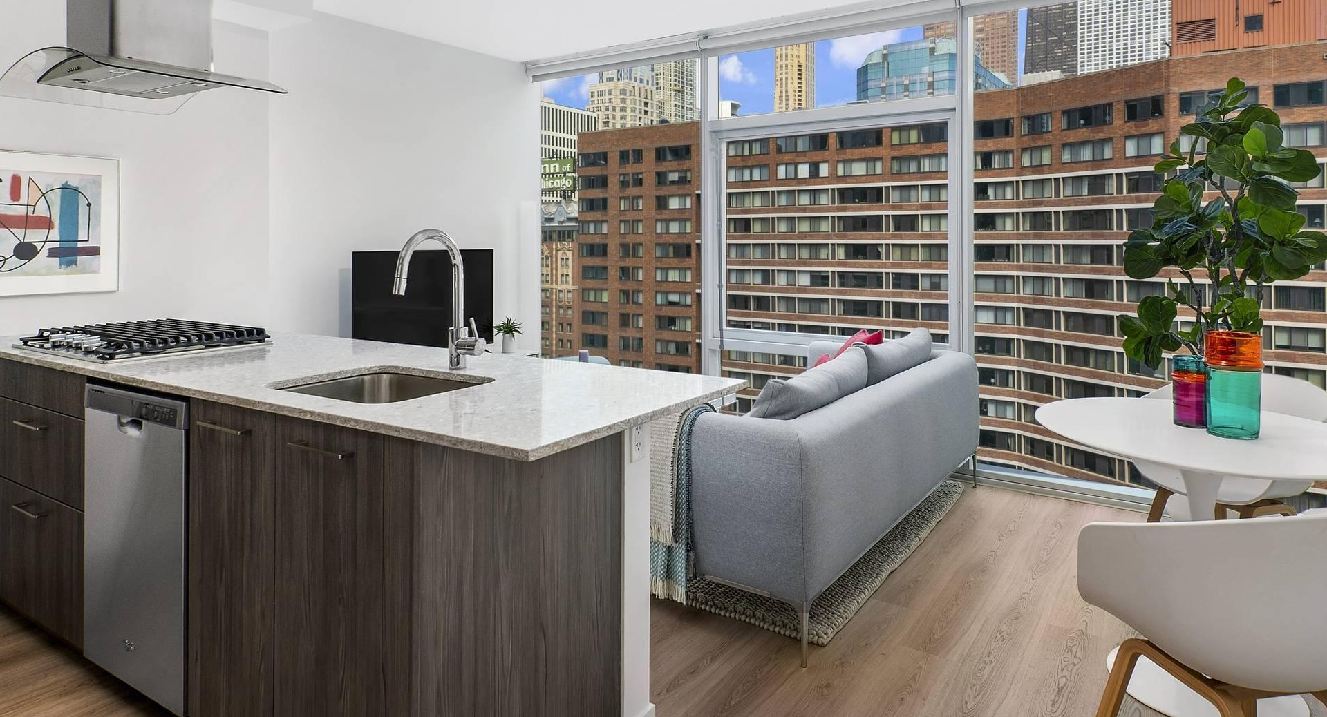 Open kitchen and living space at Optima Signature with modern finishes, breakfast bar seating, and cozy sitting area