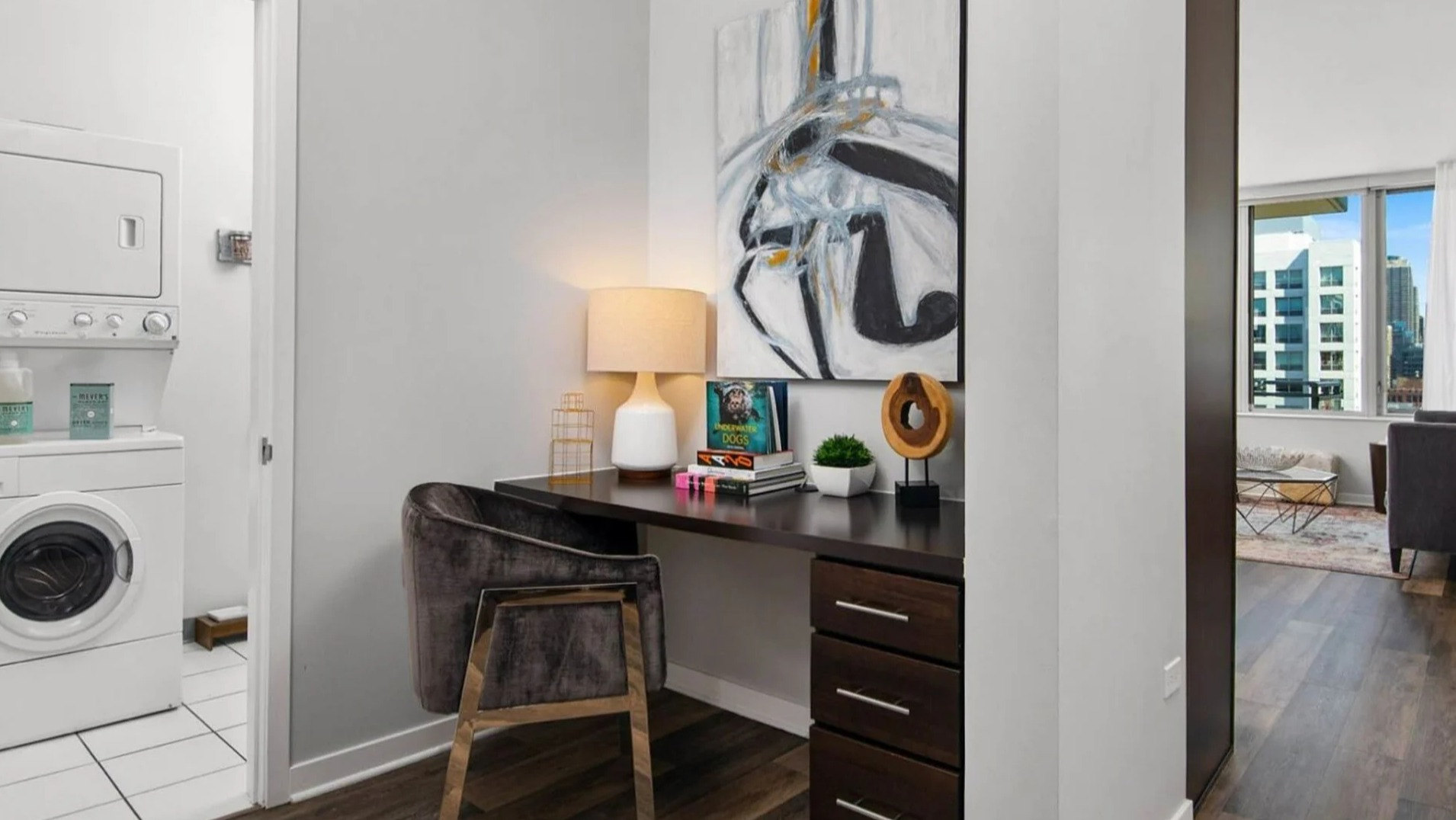 Functional apartment area at Parc Huron in Chicago, featuring a convenient workspace and a stacked in-unit washer and dryer