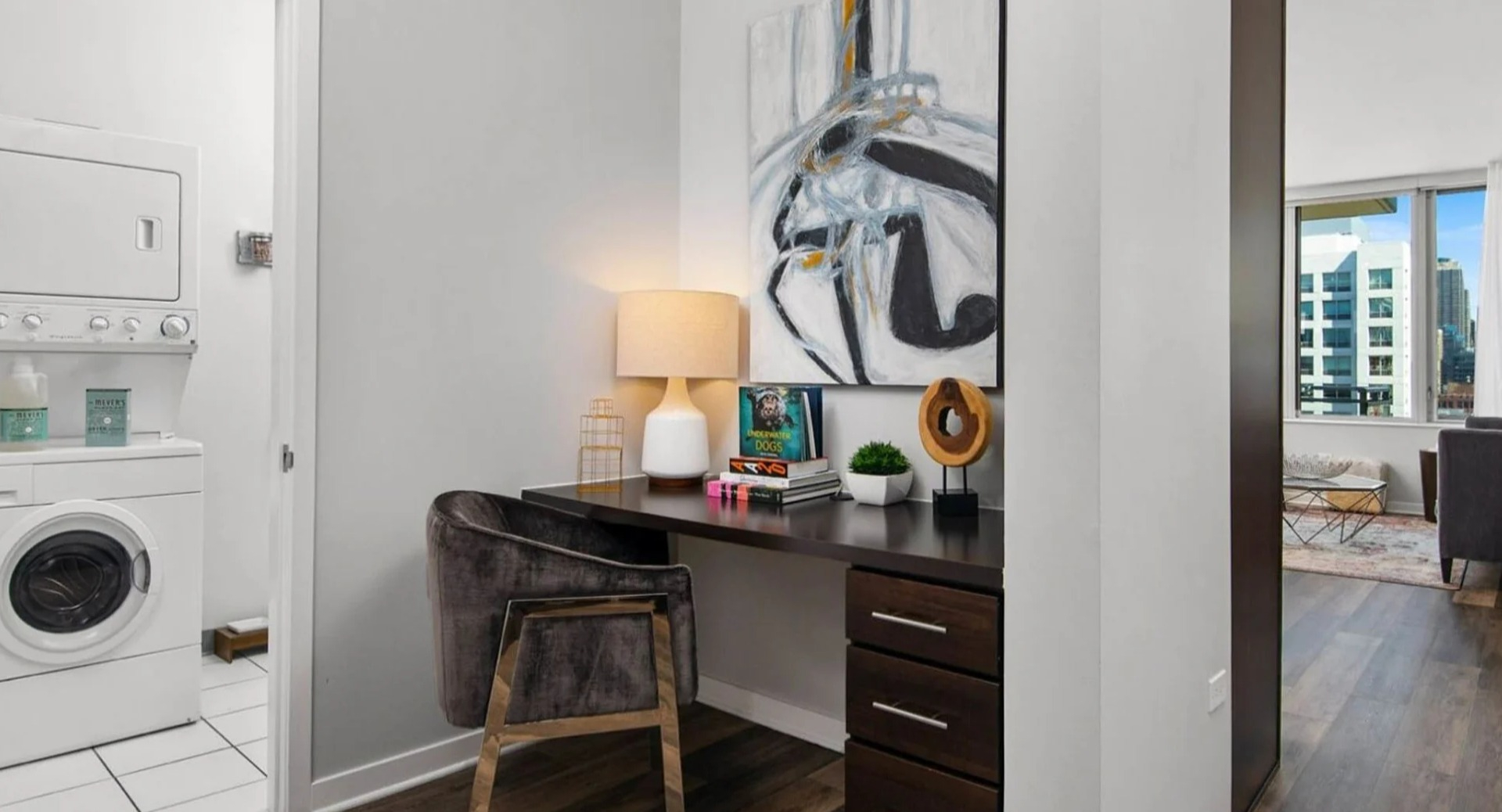 Functional apartment area at Parc Huron in Chicago, featuring a convenient workspace and a stacked in-unit washer and dryer