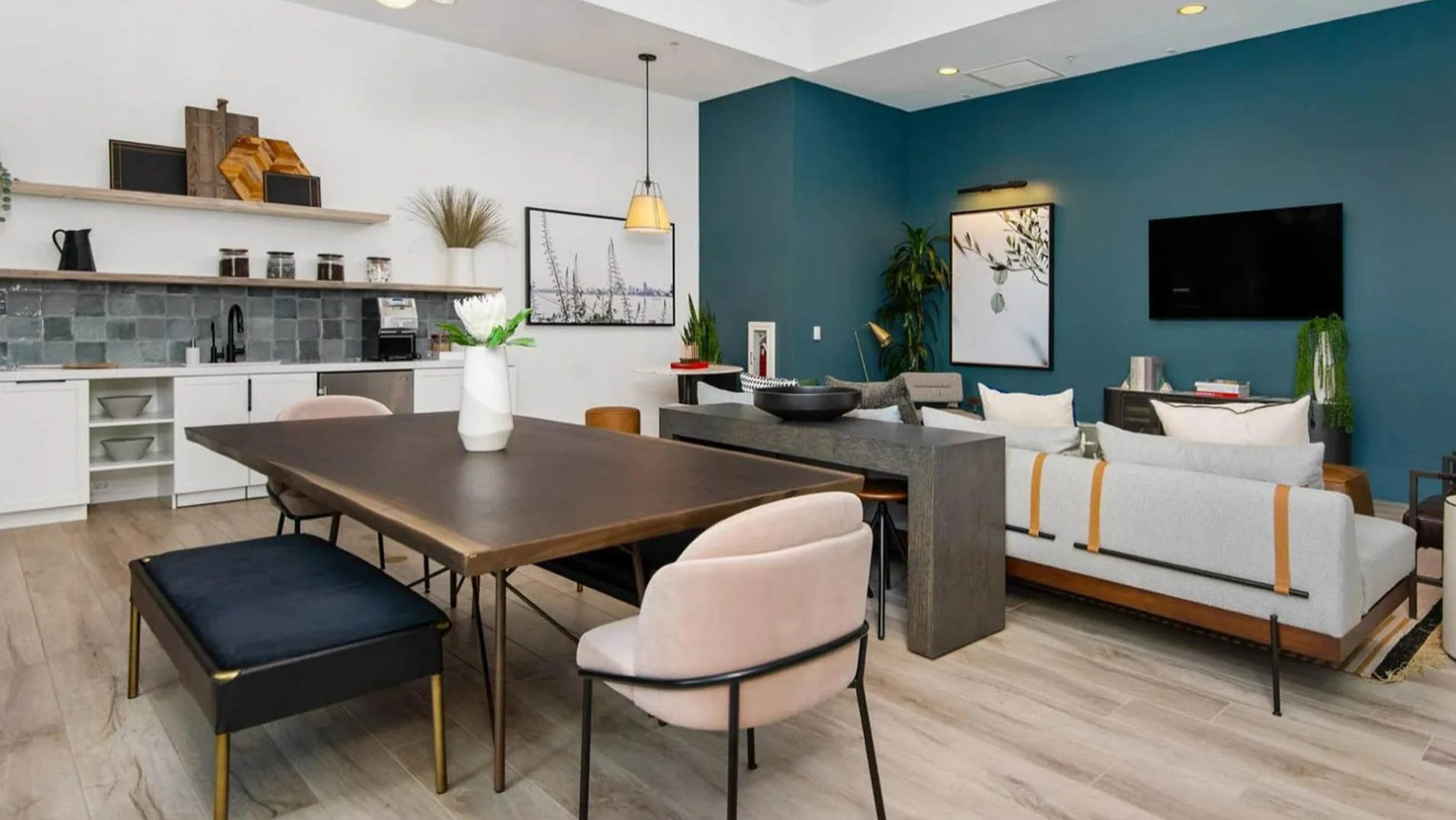 Modern clubroom at Parc Huron in Chicago, featuring a communal kitchen, long dining table, and comfortable lounge seating areas