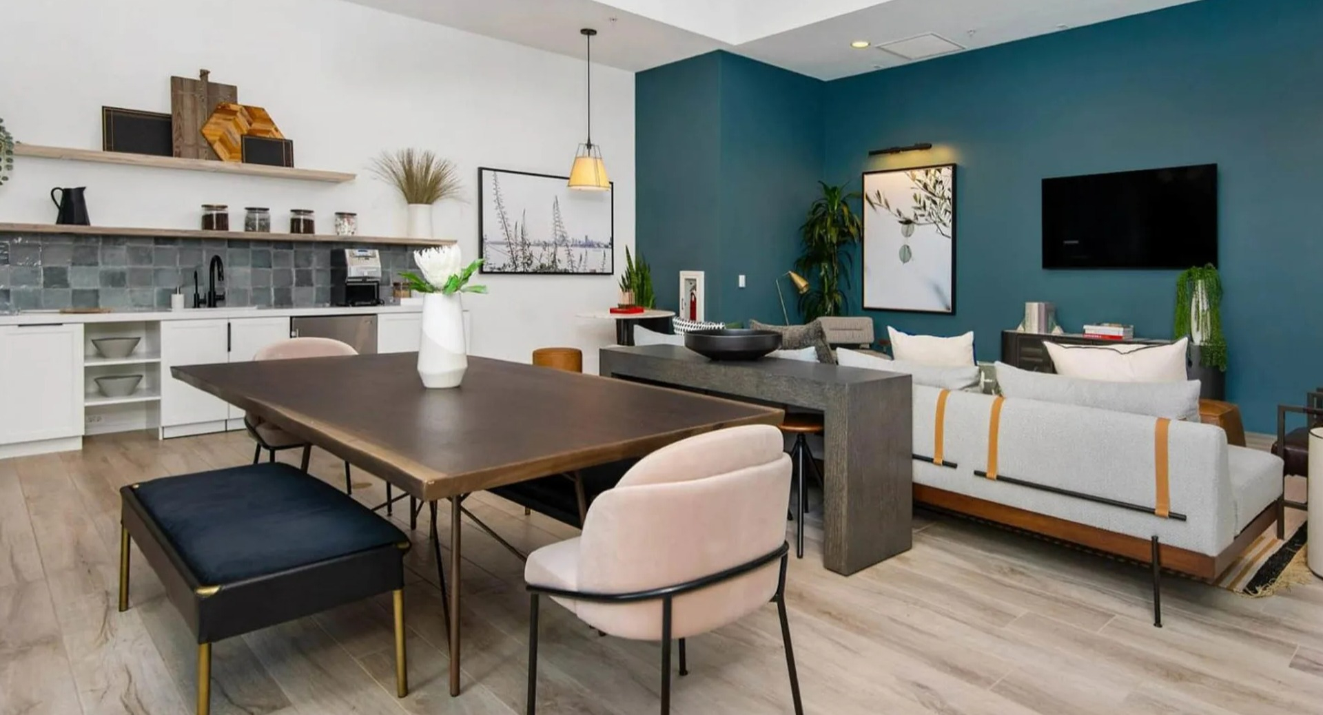 Modern clubroom at Parc Huron in Chicago, featuring a communal kitchen, long dining table, and comfortable lounge seating areas