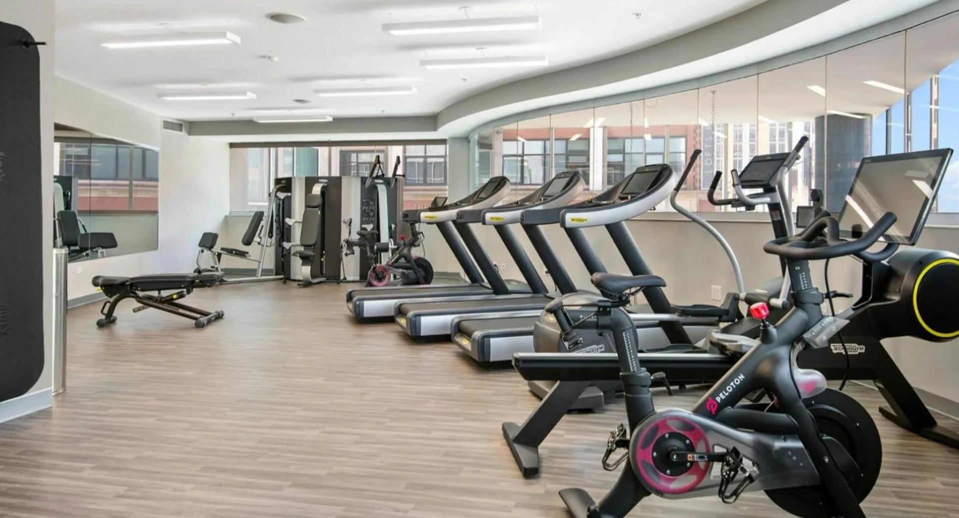 Well-equipped fitness center at Parc Huron in Chicago, featuring various cardio machines, including Pelotons, and ample workout space