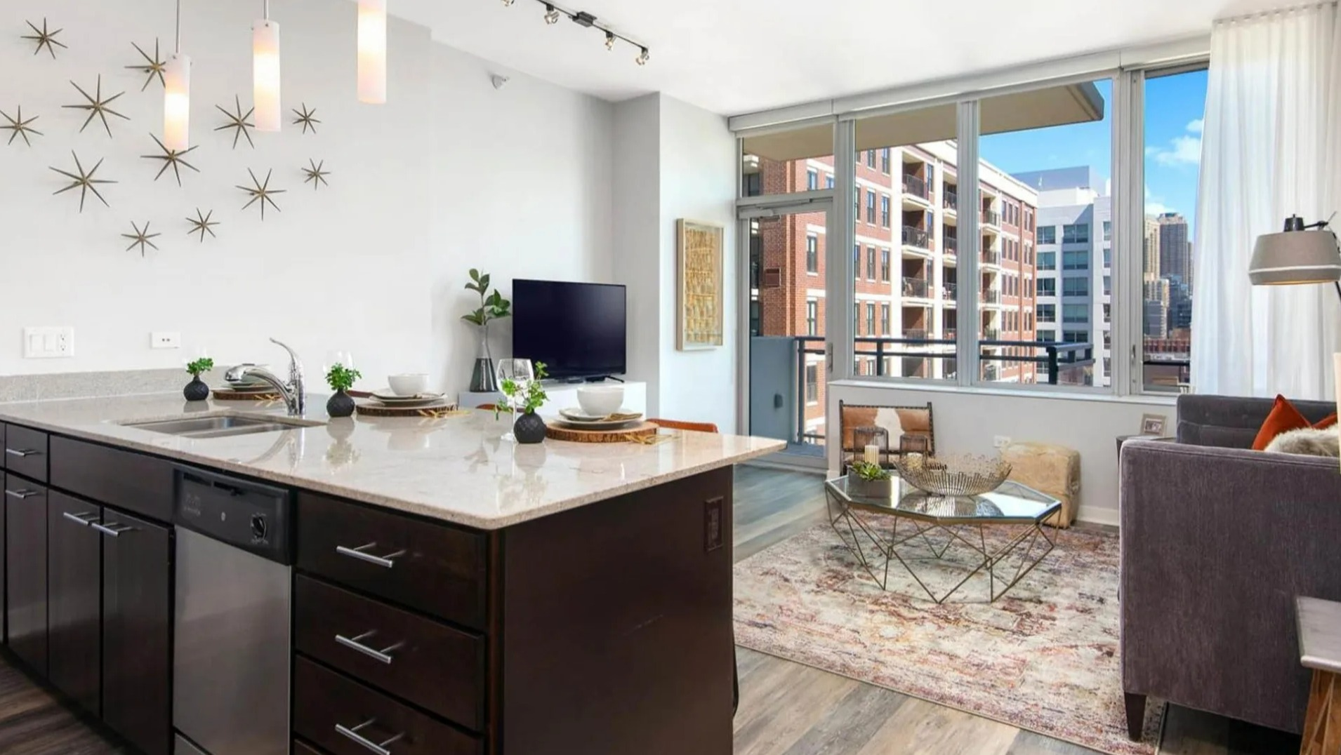 Bright apartment with a modern kitchen and comfortable living room at Parc Huron in Chicago, featuring a breakfast bar and city views