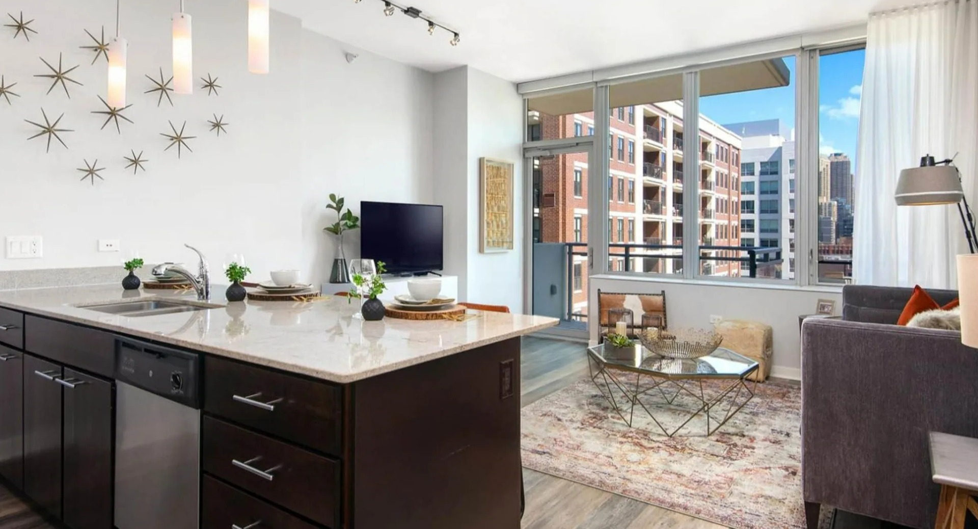Bright apartment with a modern kitchen and comfortable living room at Parc Huron in Chicago, featuring a breakfast bar and city views