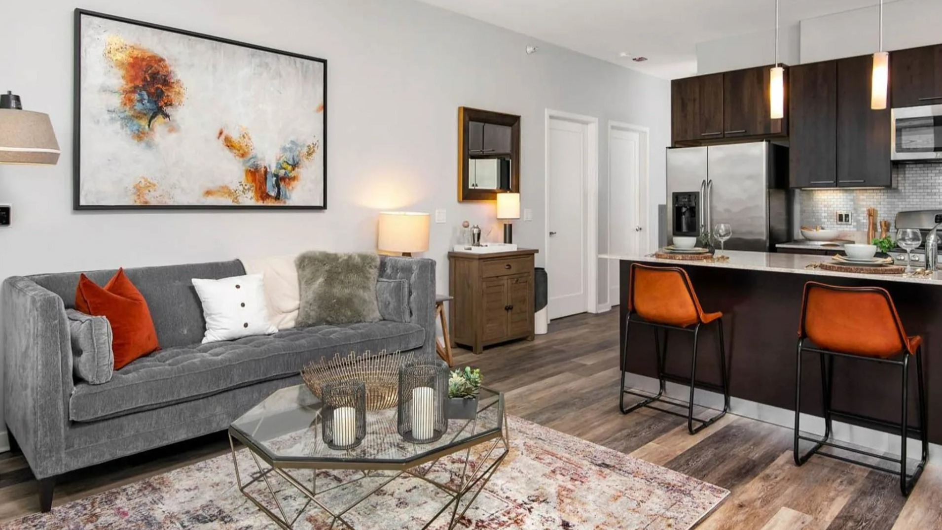 Open-concept living room and kitchen at Parc Huron in Chicago, featuring a comfortable sofa, elegant decor, and a breakfast bar