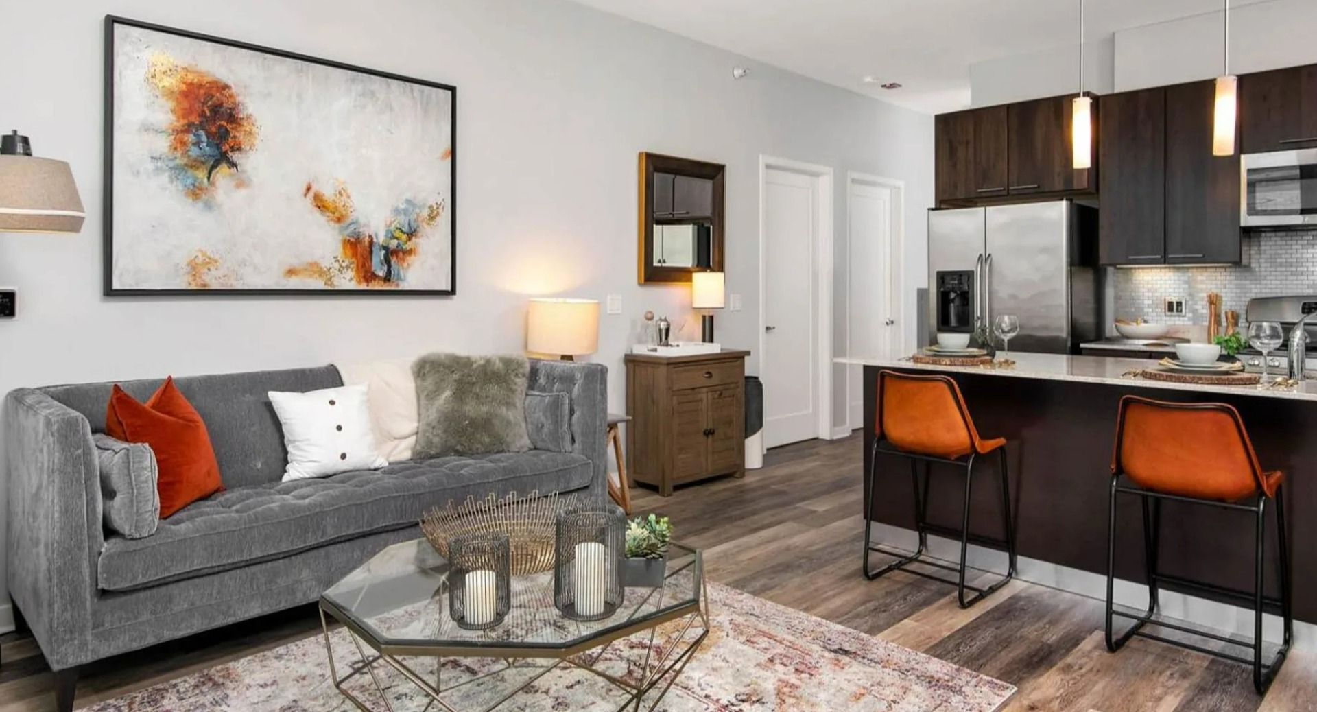 Open-concept living room and kitchen at Parc Huron in Chicago, featuring a comfortable sofa, elegant decor, and a breakfast bar