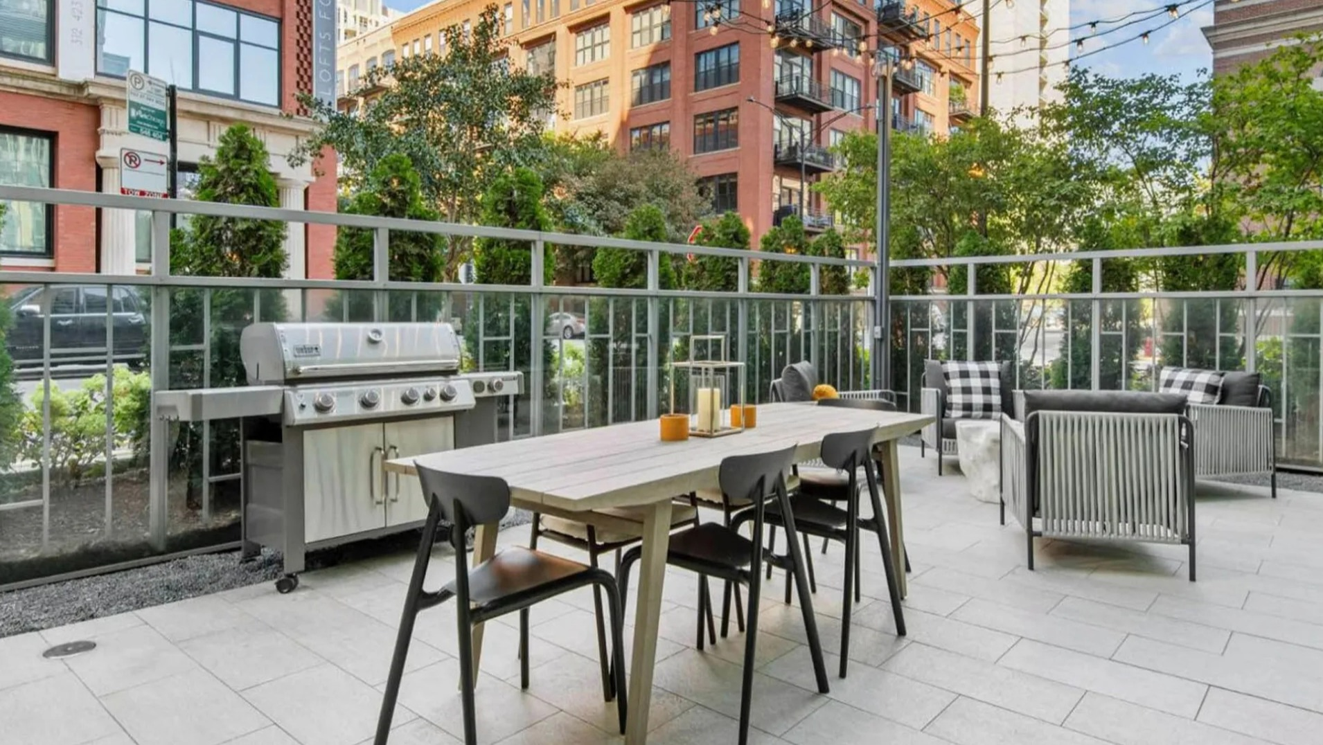 Inviting outdoor grilling patio at Parc Huron in Chicago, featuring a barbecue, dining table, and lounge seating for residents