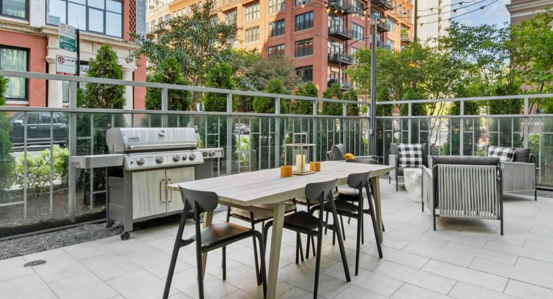 Inviting outdoor grilling patio at Parc Huron in Chicago, featuring a barbecue, dining table, and lounge seating for residents