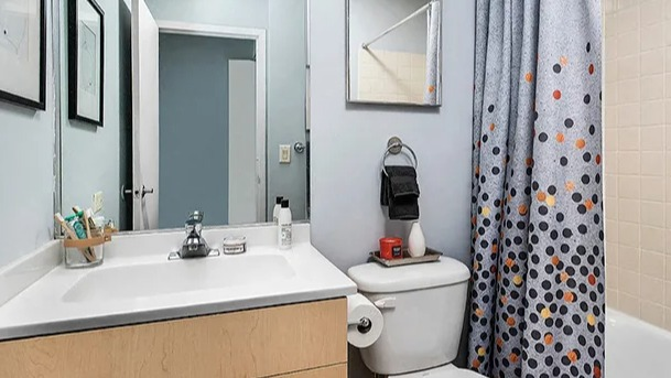 Classic bathroom with a vanity, mirror, and a bathtub with a polka-dot shower curtain at Park Michigan in Chicago