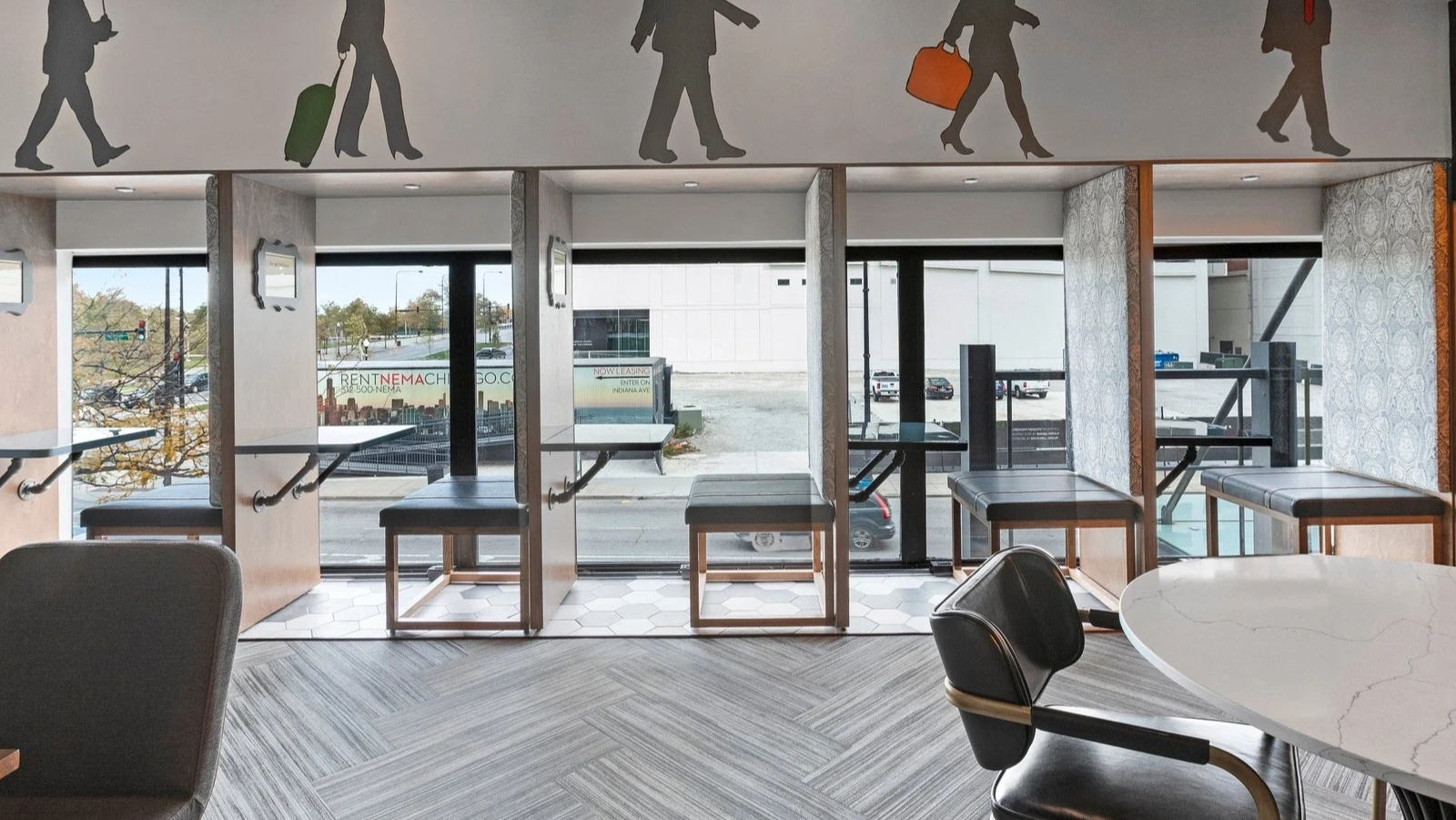 Innovative coworking space at Park Michigan in Chicago, featuring semi-private booths and a dynamic mural depicting urban life