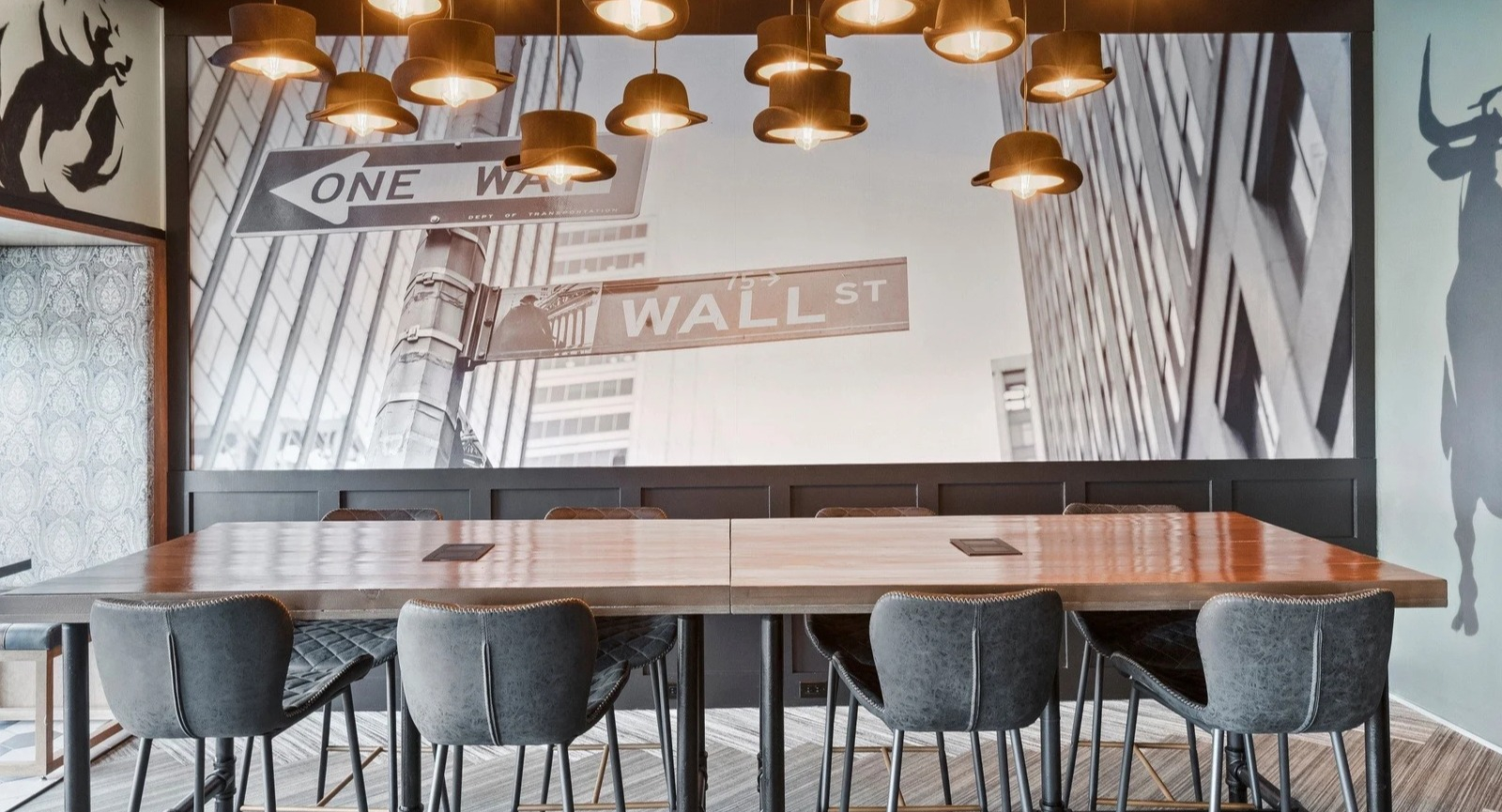 Unique coworking and dining space at Park Michigan in Chicago, featuring a large communal table and Wall Street-themed murals