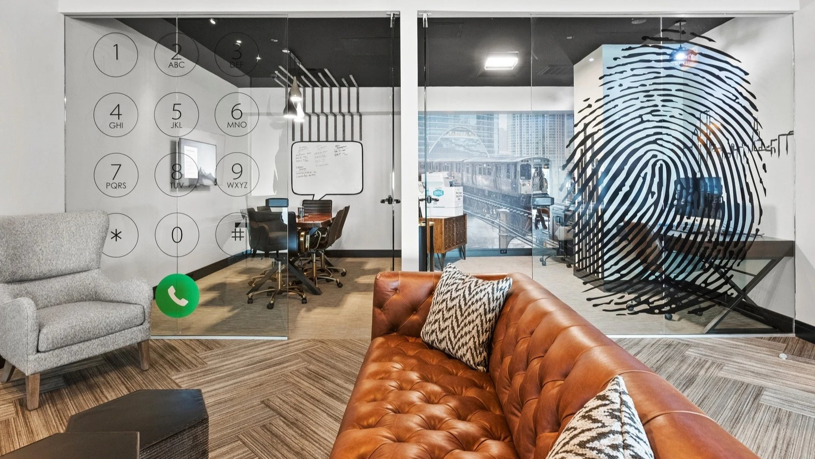 Modern private work pods at Park Michigan in Chicago, featuring glass walls with graphic designs, comfortable seating, and desk space