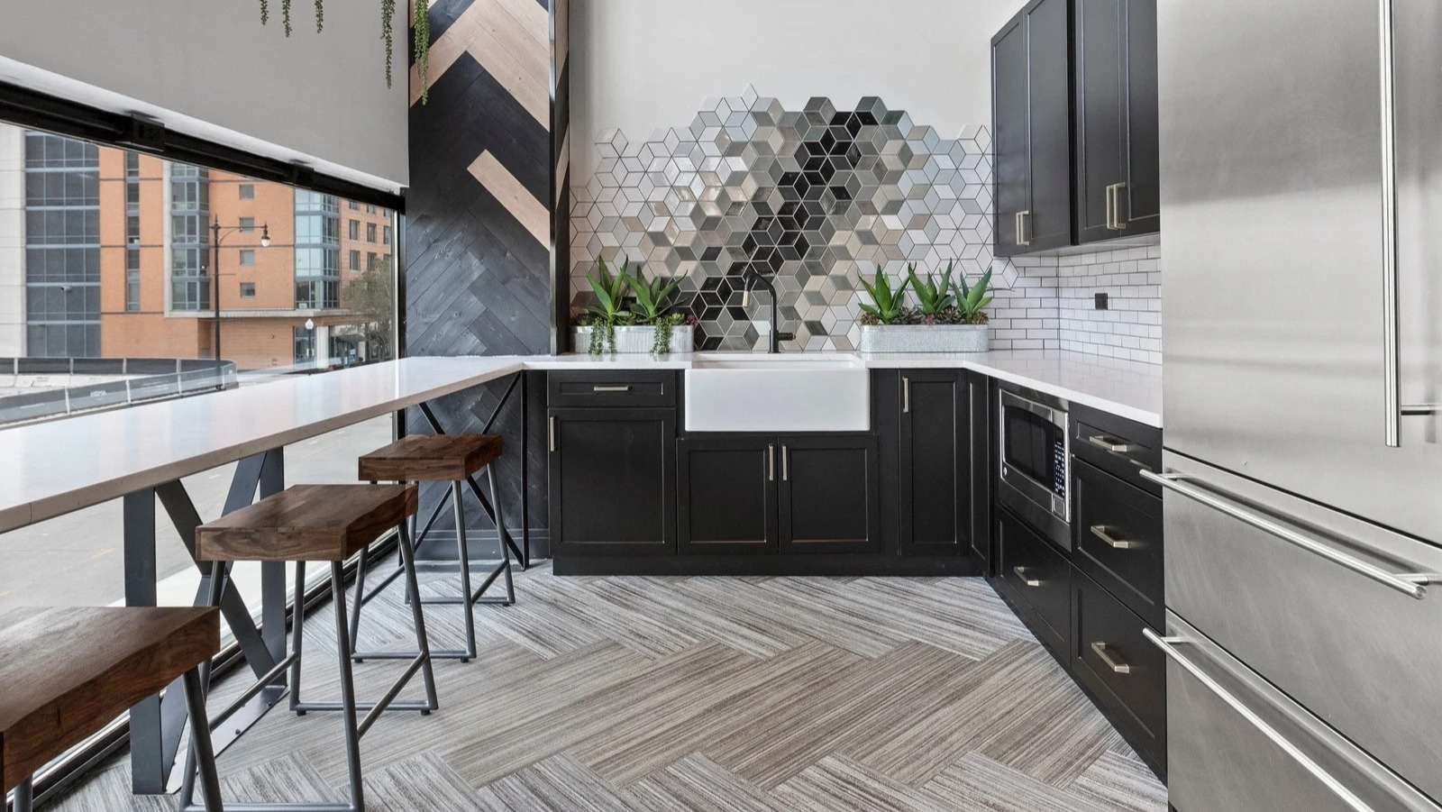 Stylish resident kitchenette at Park Michigan in Chicago, featuring modern appliances, a bar area with stools, and chic decor