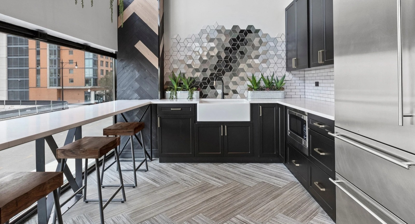 Stylish resident kitchenette at Park Michigan in Chicago, featuring modern appliances, a bar area with stools, and chic decor