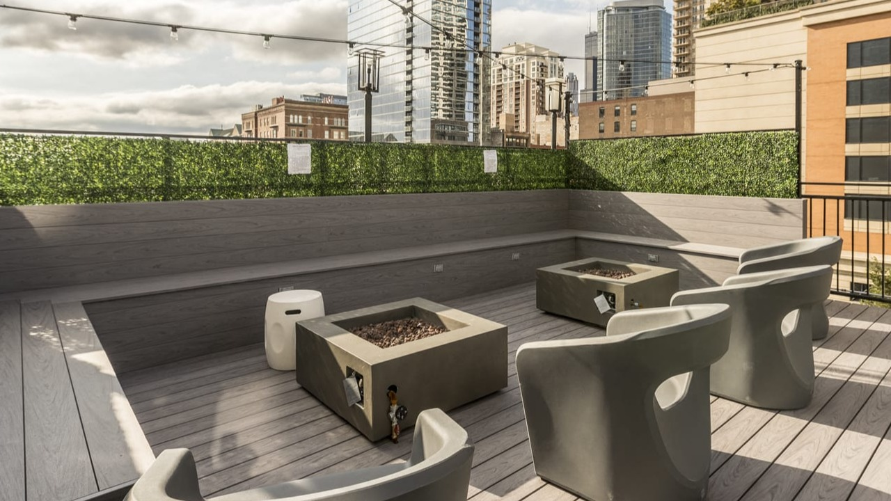 Inviting rooftop terrace at Park Michigan in Chicago, featuring comfortable seating, modern fire pits, and city skyline views