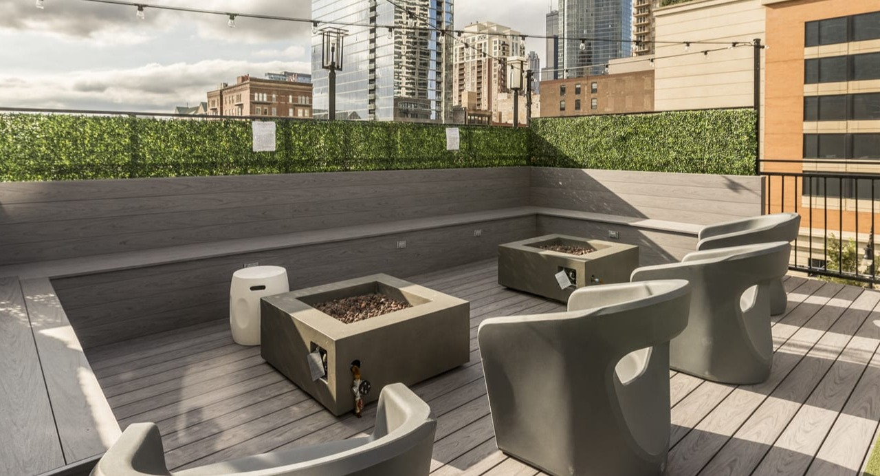 Inviting rooftop terrace at Park Michigan in Chicago, featuring comfortable seating, modern fire pits, and city skyline views