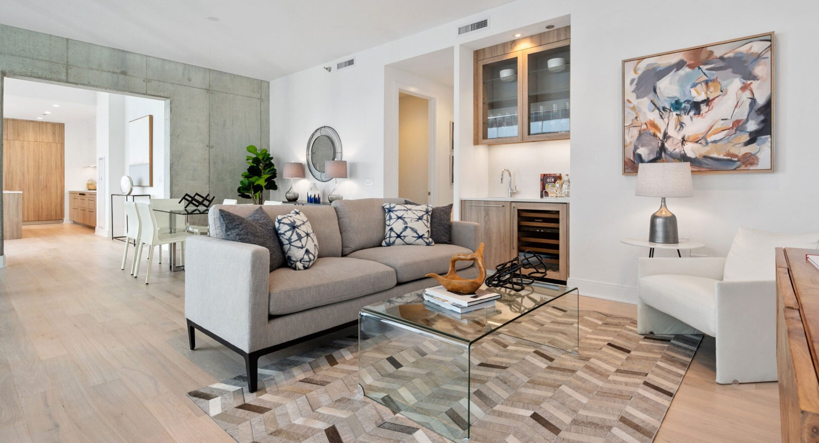 Contemporary living room with a comfortable sofa, modern rug, and a built-in wet bar perfect for entertaining at Parkline Chicago in Chicago