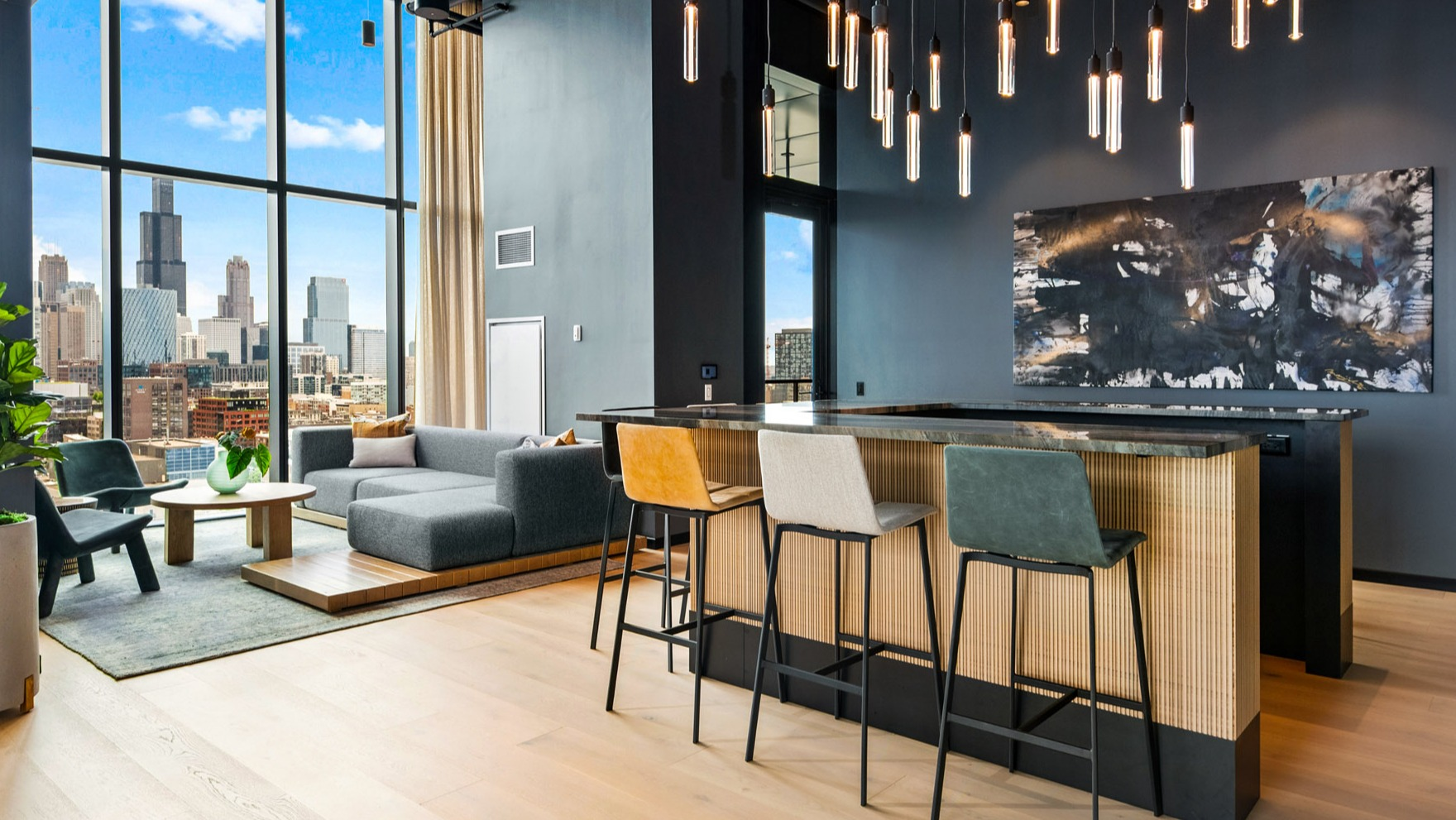 Stylish clubroom at Parq Fulton in Chicago, featuring a chic bar area with seating, a comfortable lounge, and stunning city skyline views