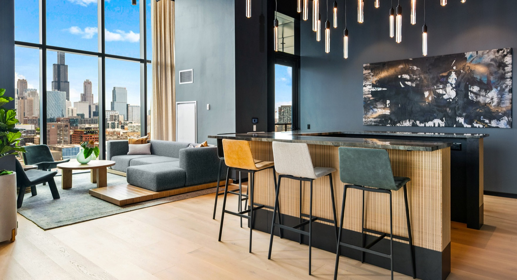 Stylish clubroom at Parq Fulton in Chicago, featuring a chic bar area with seating, a comfortable lounge, and stunning city skyline views