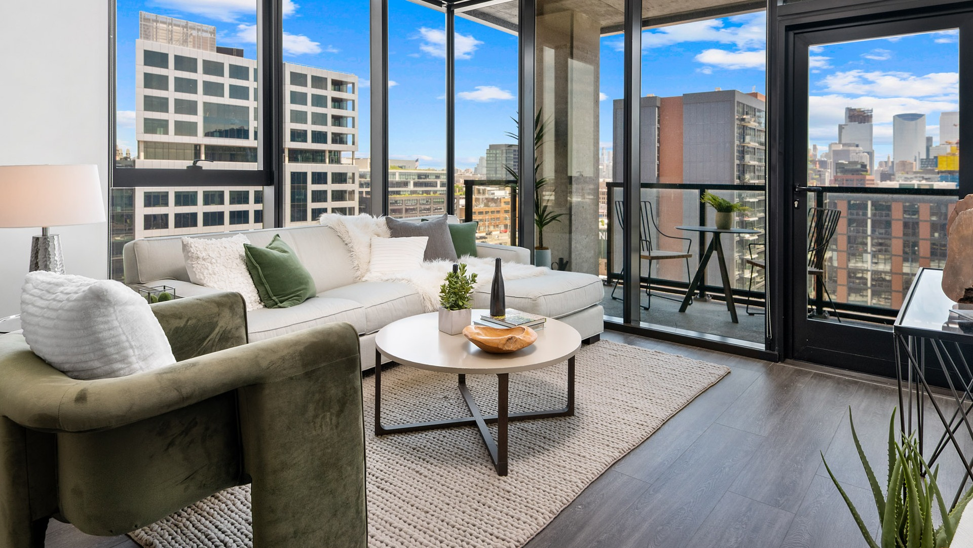 Bright apartment living room at Parq Fulton in Chicago, featuring a comfortable sofa, elegant decor, and a balcony with city views