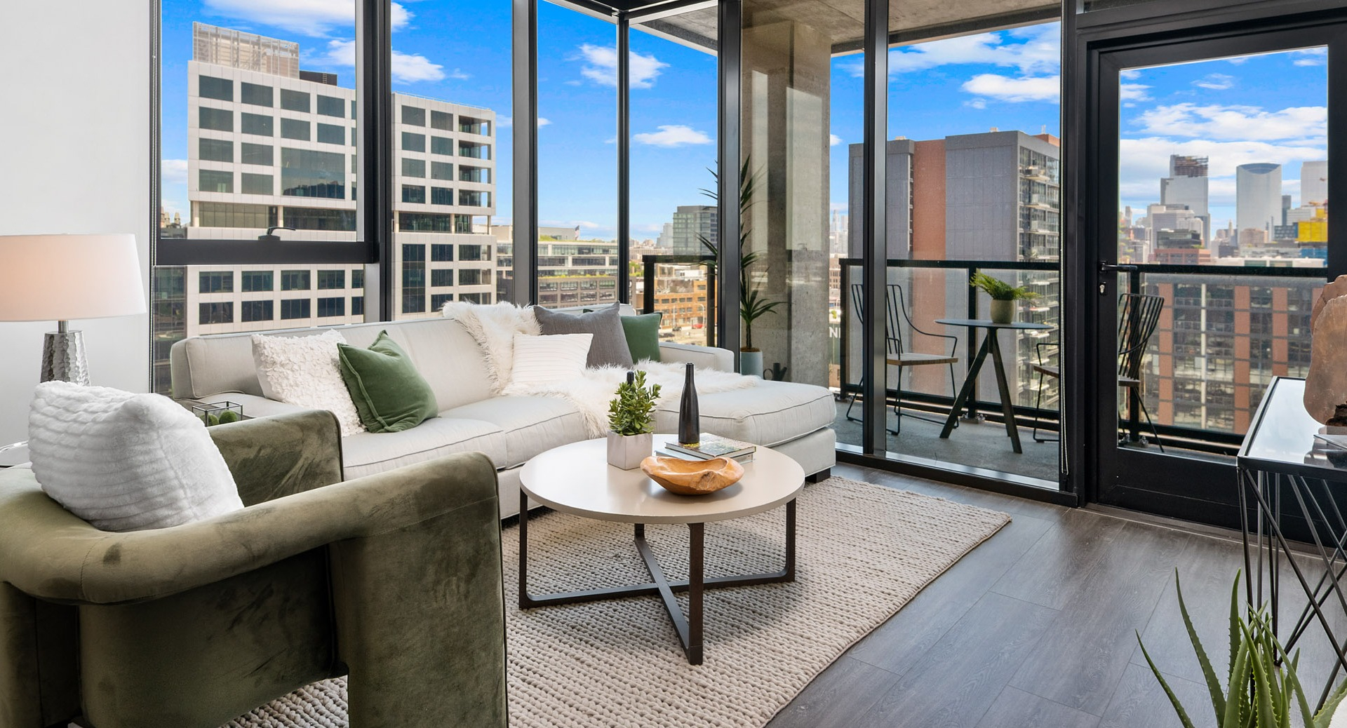Bright apartment living room at Parq Fulton in Chicago, featuring a comfortable sofa, elegant decor, and a balcony with city views