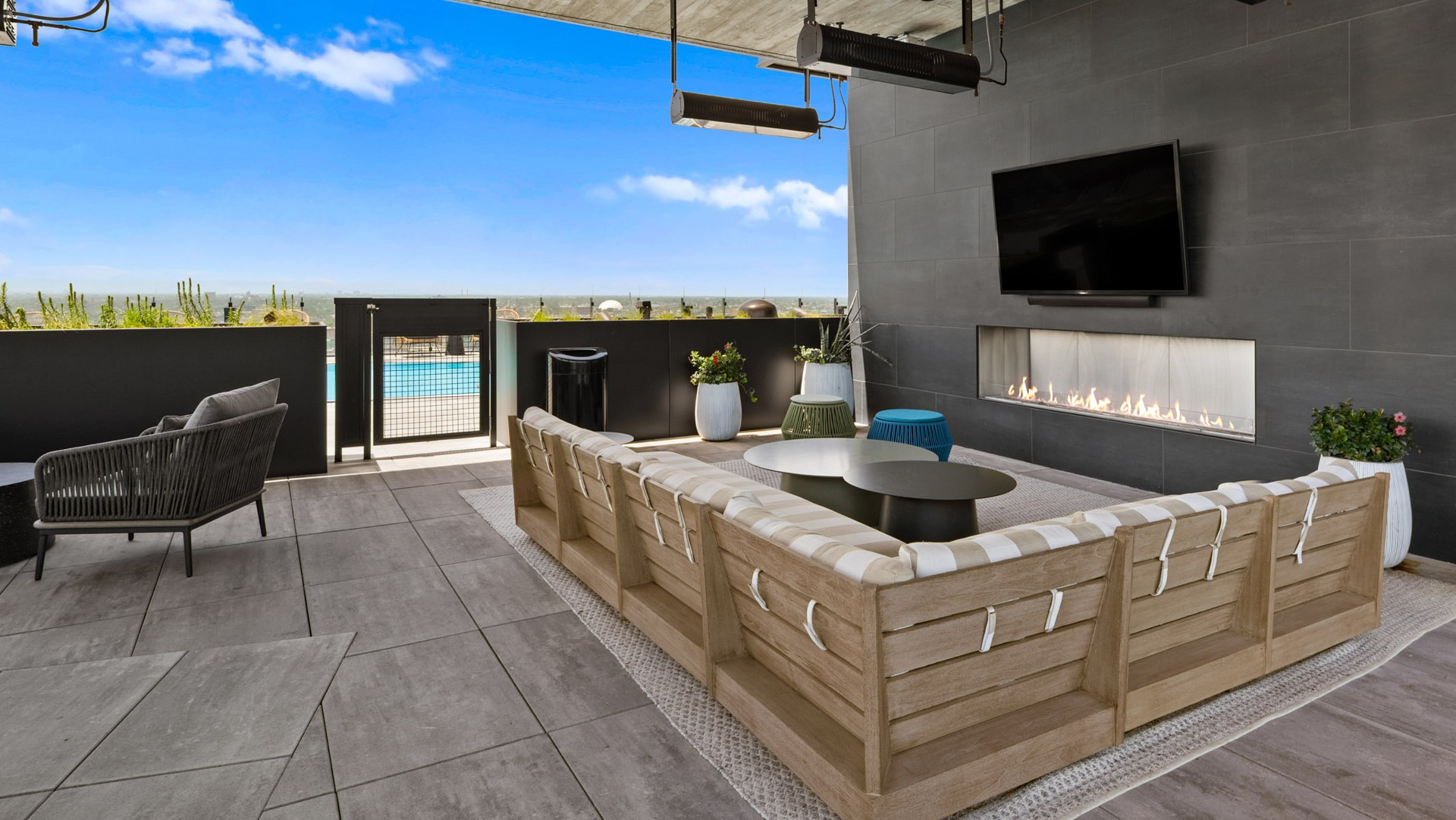 Chic outdoor lounge area at Parq Fulton in Chicago, featuring comfortable seating, a modern fireplace, and views of the pool deck and city