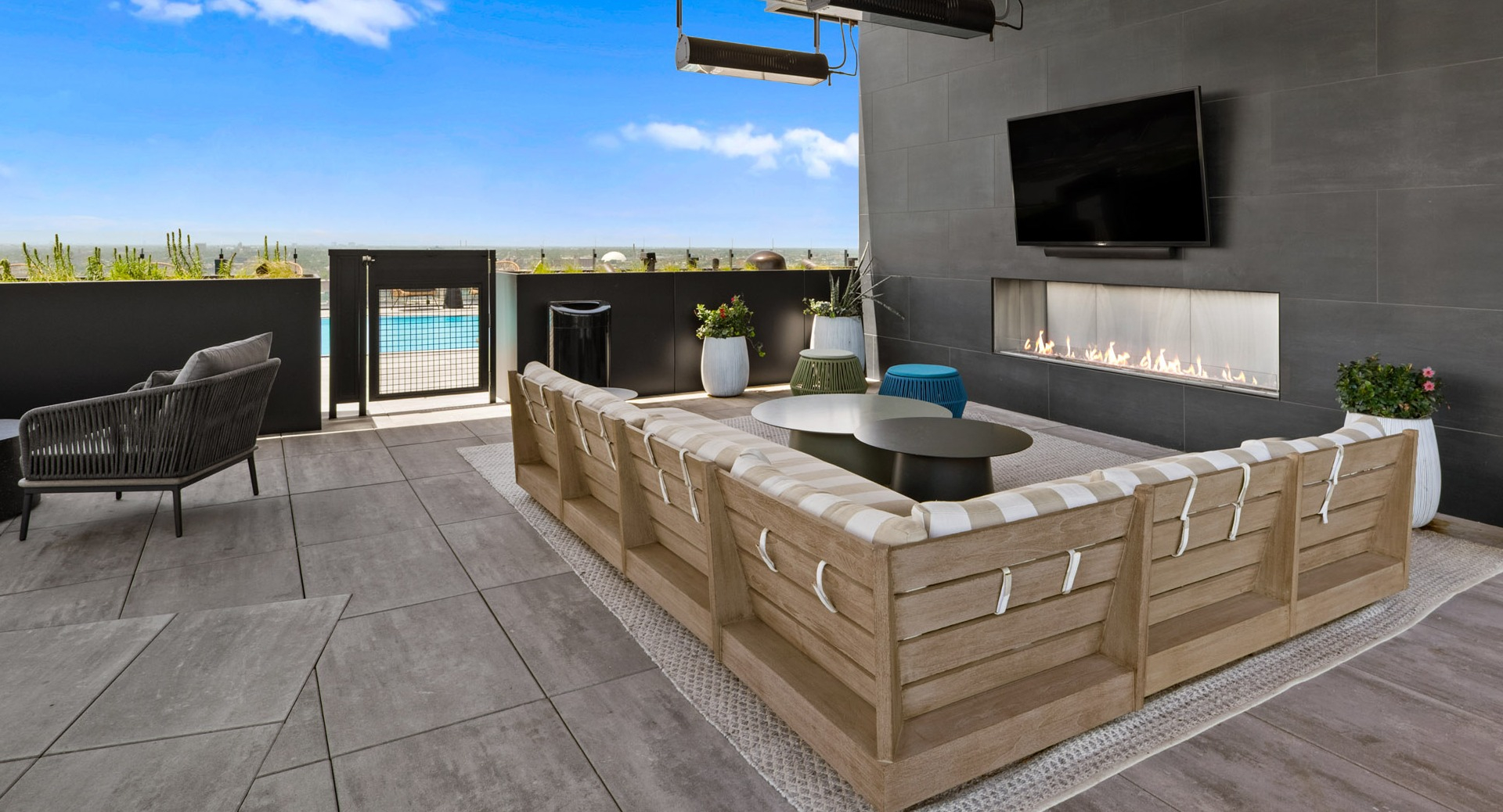 Chic outdoor lounge area at Parq Fulton in Chicago, featuring comfortable seating, a modern fireplace, and views of the pool deck and city
