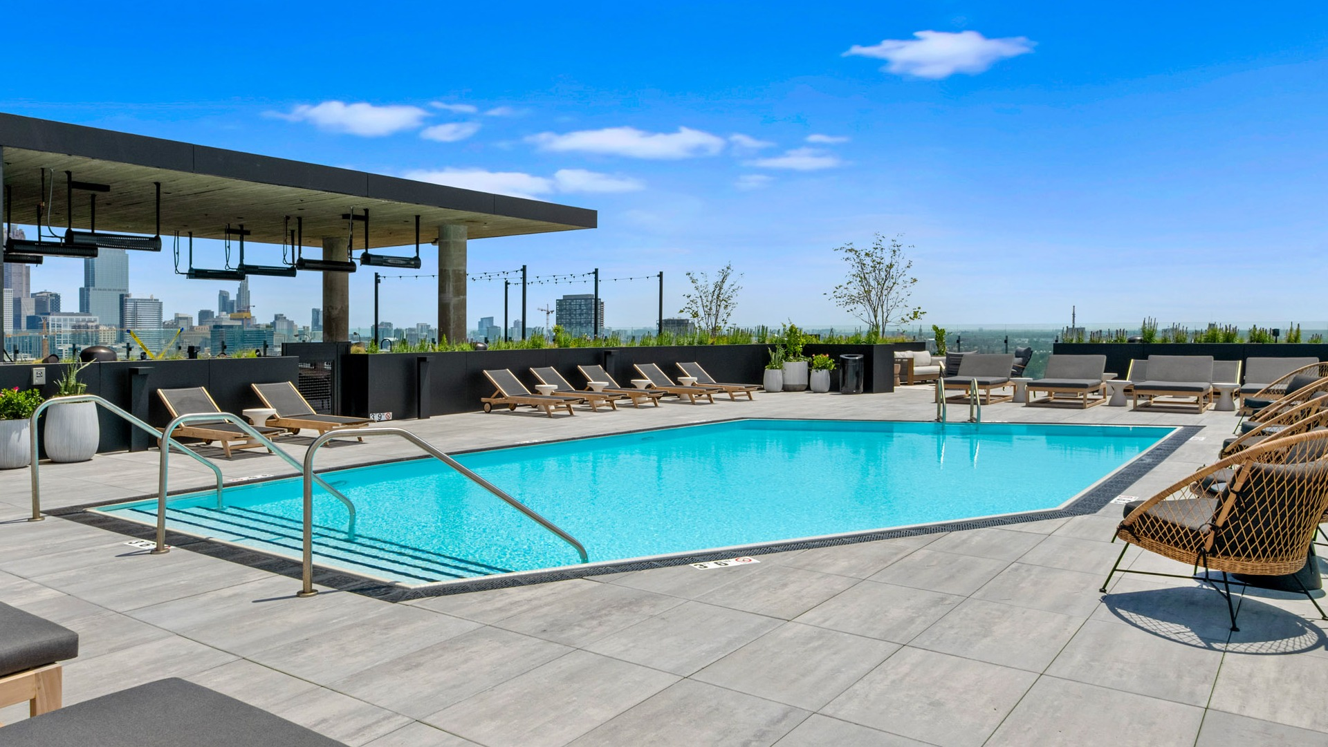 Inviting swimming pool area at Parq Fulton in Chicago, surrounded by lounge seating and offering picturesque city skyline views