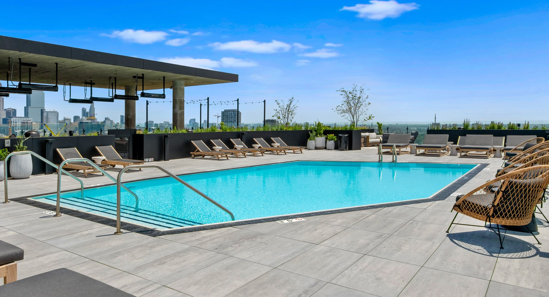 Inviting swimming pool area at Parq Fulton in Chicago, surrounded by lounge seating and offering picturesque city skyline views
