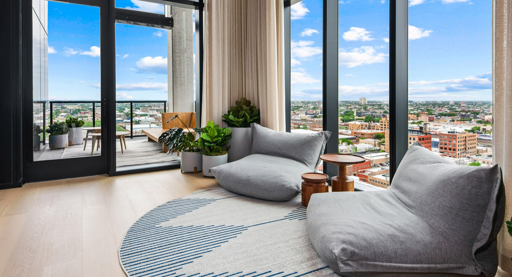 Cozy resident lounge at Parq Fulton in Chicago, featuring comfortable seating, stylish decor, and access to a balcony with urban views