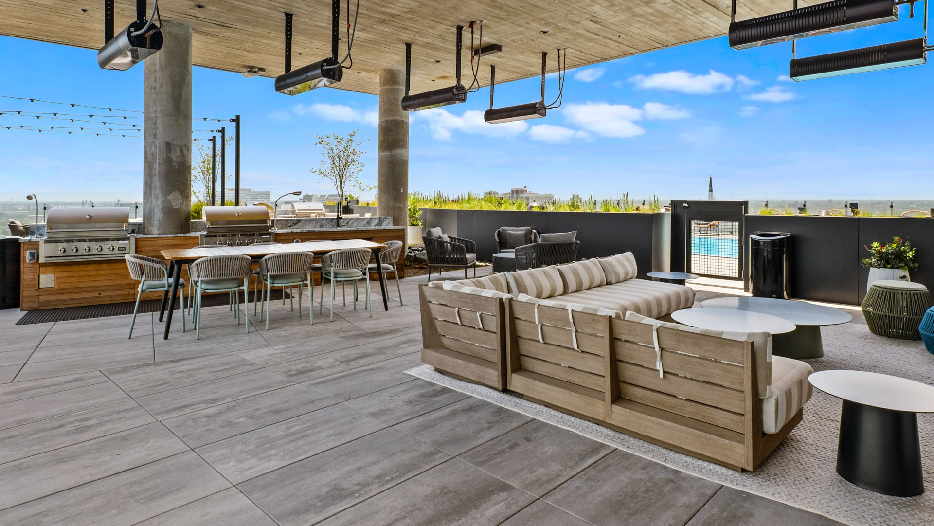 Vibrant rooftop lounge at Parq Fulton in Chicago, featuring comfortable seating, dining tables, outdoor grills, and a refreshing pool view