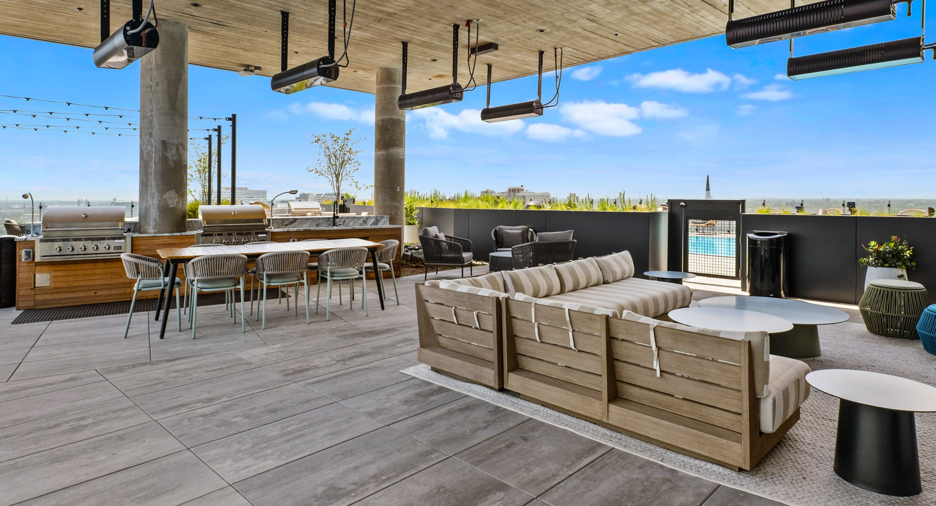 Vibrant rooftop lounge at Parq Fulton in Chicago, featuring comfortable seating, dining tables, outdoor grills, and a refreshing pool view